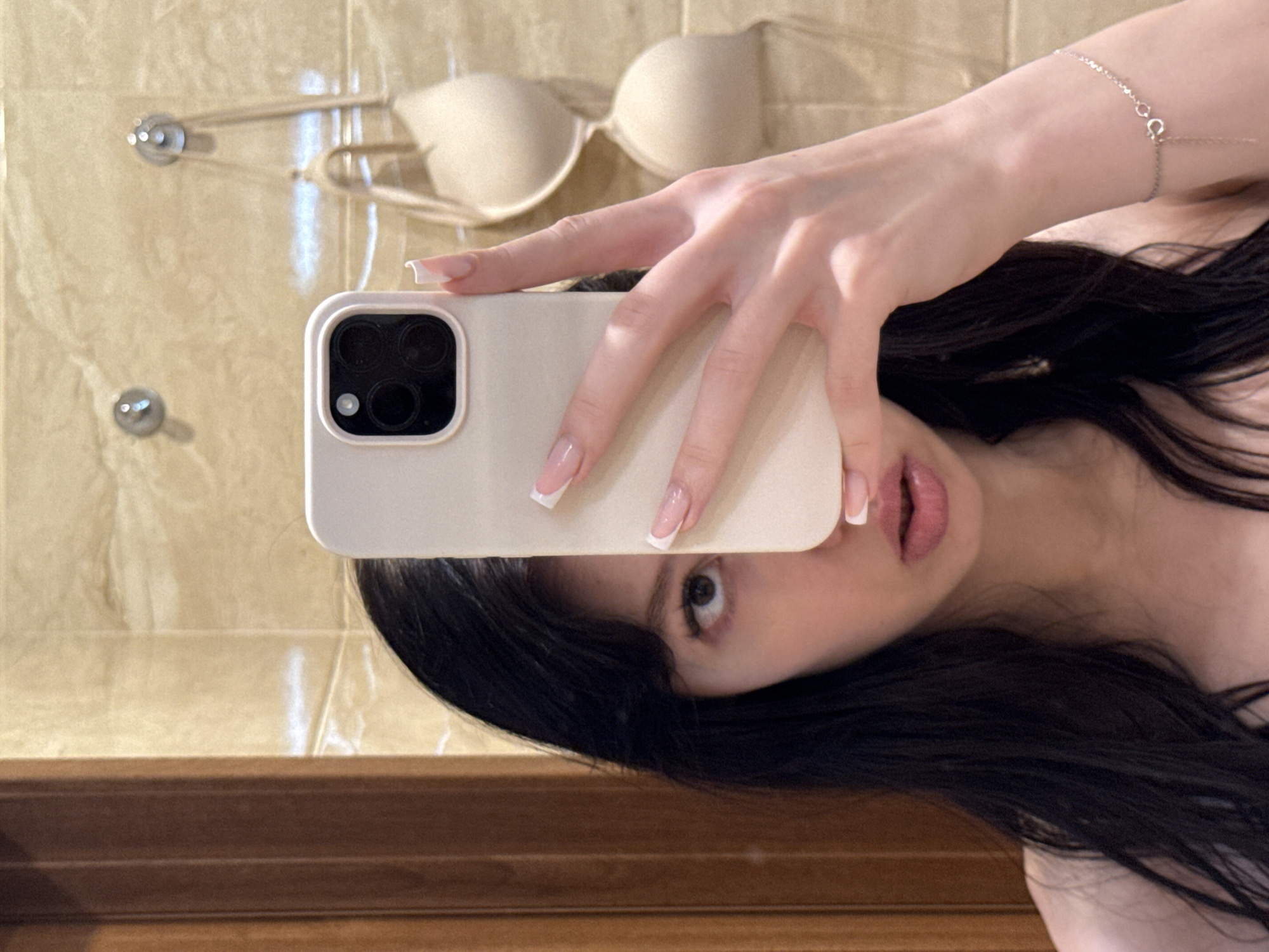 Bathroom mirror selfie, phone raised, face partially obscured