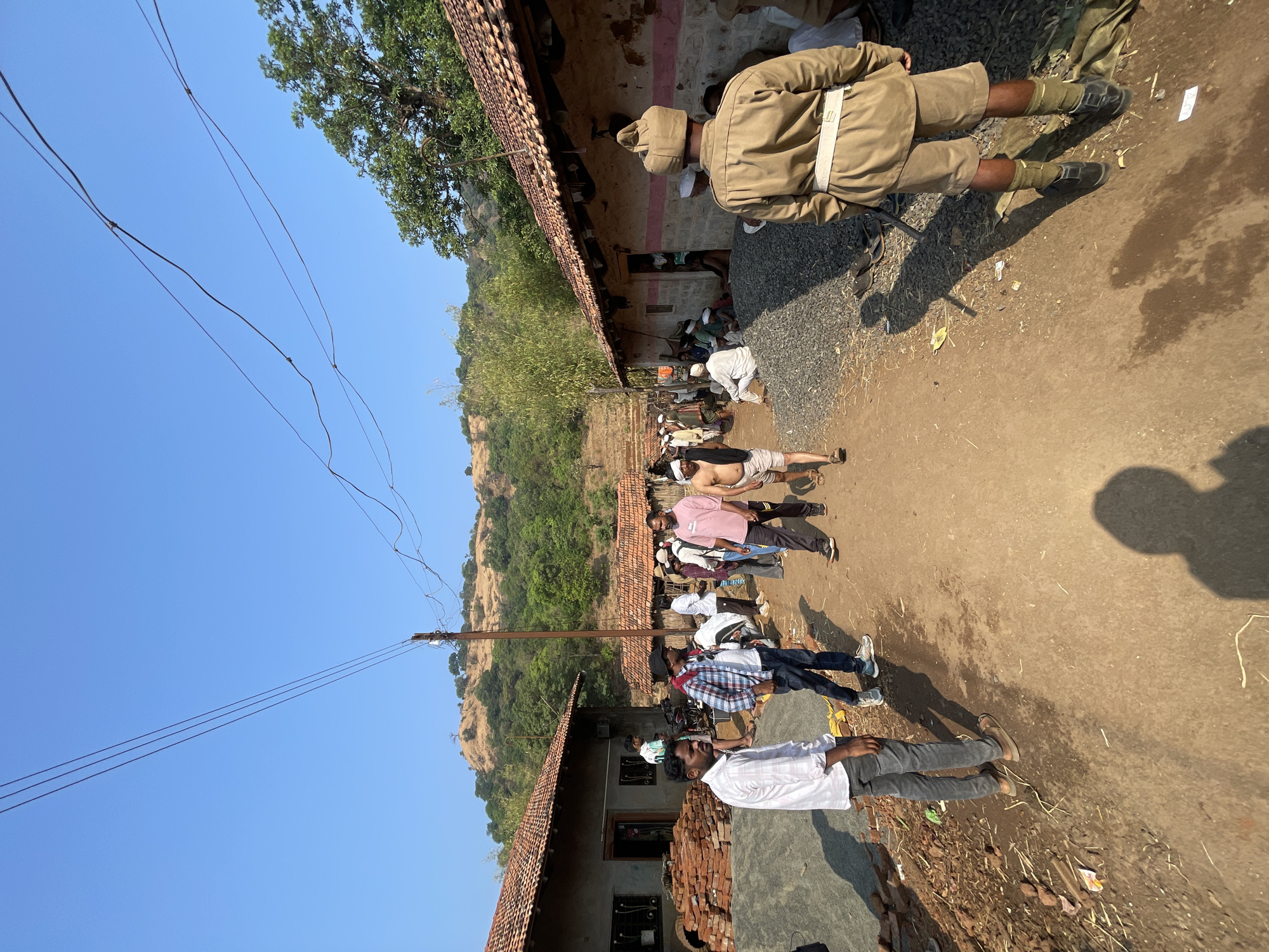 People queue along dirt path in Sonurle, India