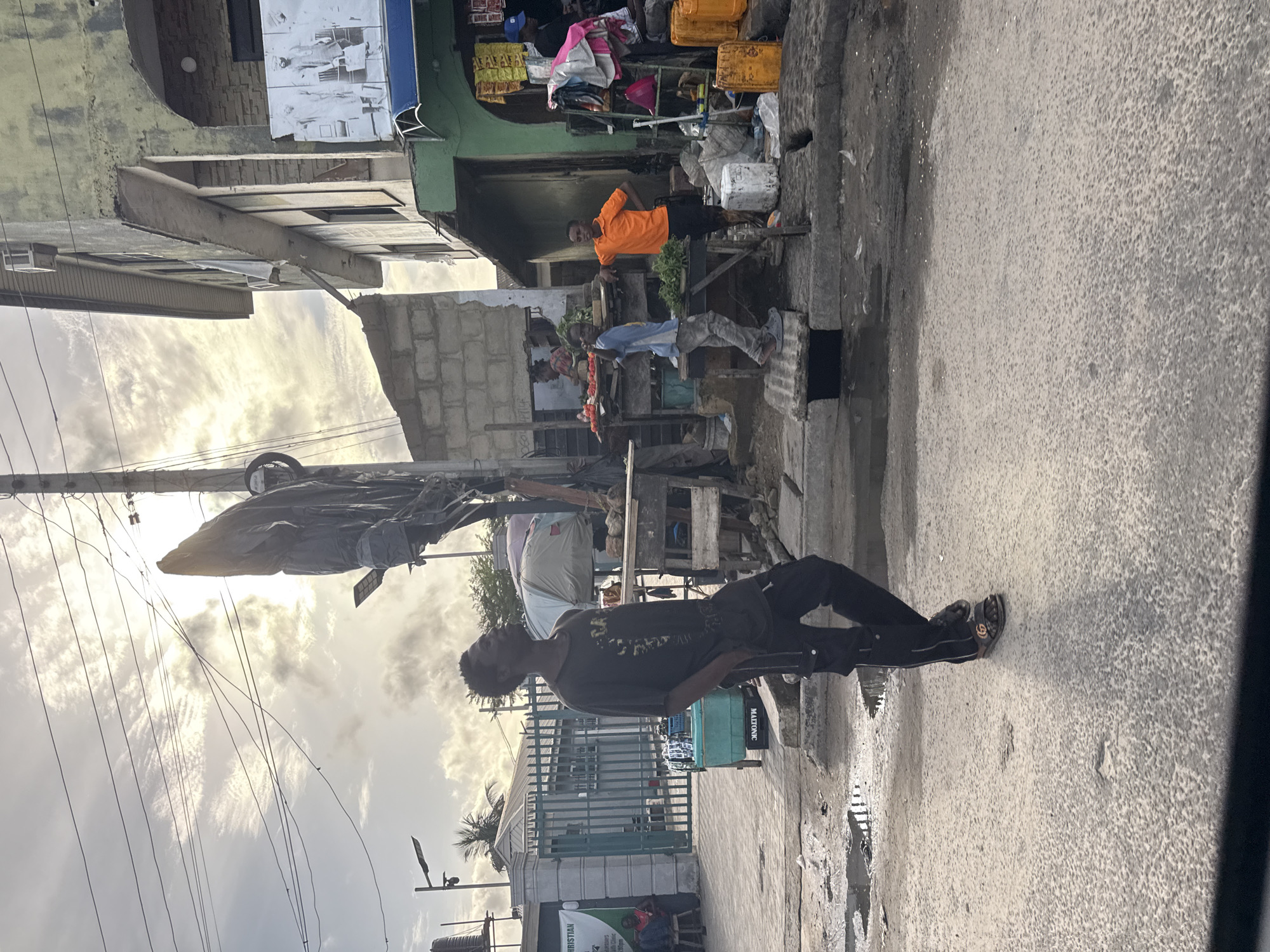 Young man stands near market in Ado, Nigeria