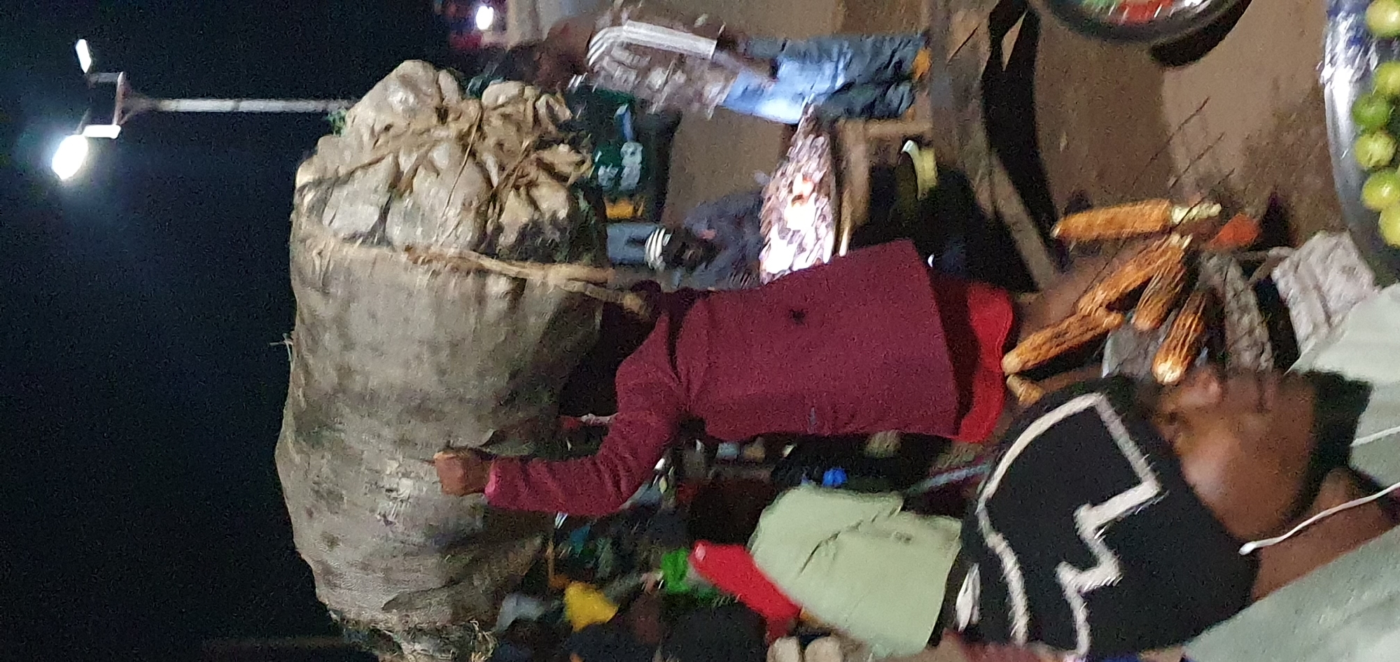 Night market activity in Bukuru, Nigeria — loads carried on heads