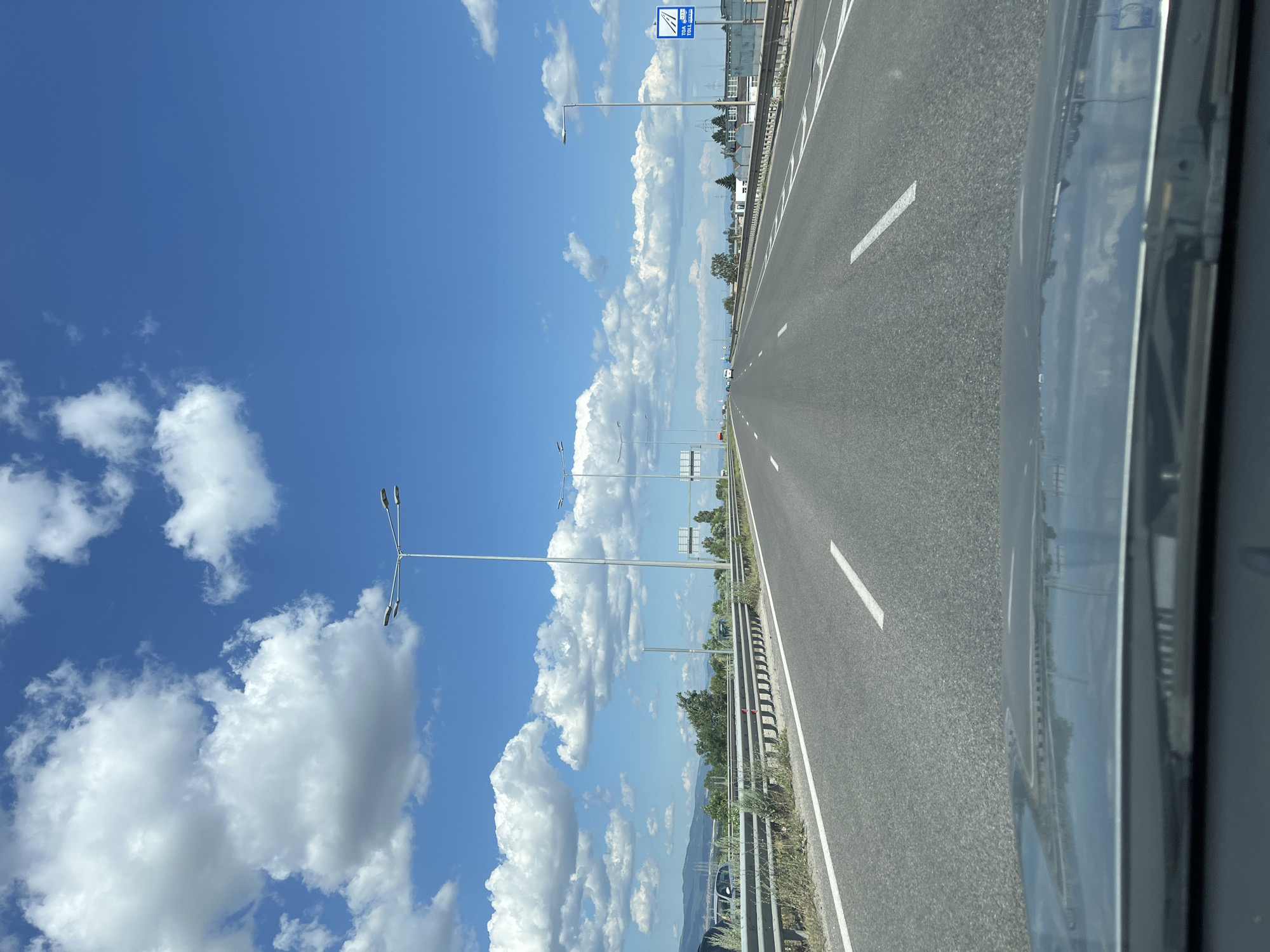 Sunny highway drive through mountainous landscape under blue skies