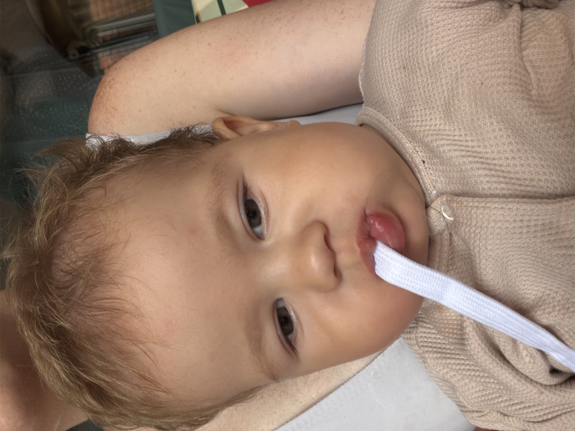 Quiet indoor moment: baby and bare feet on tiled floor
