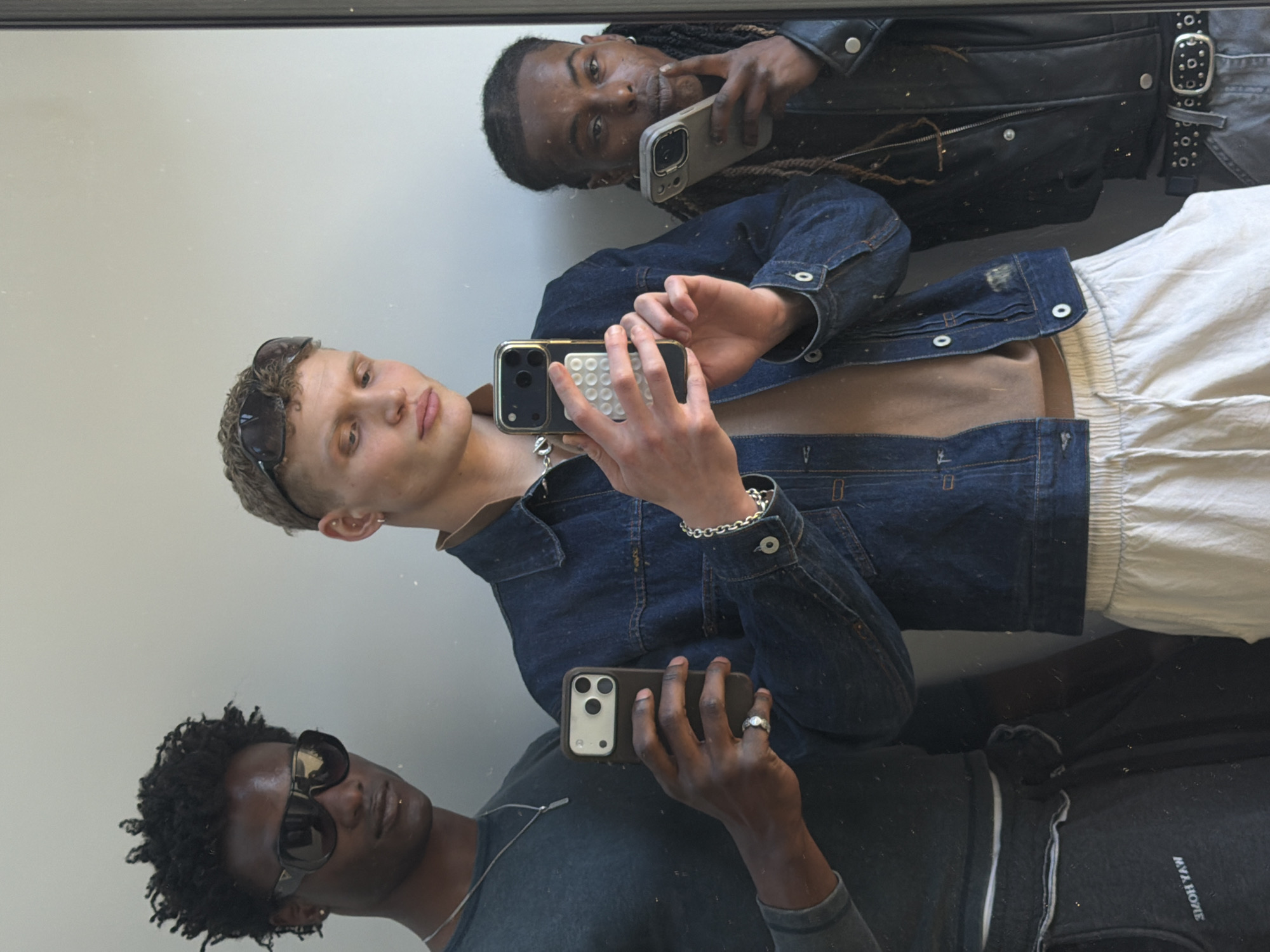 Three men take mirror selfie in London indoor location