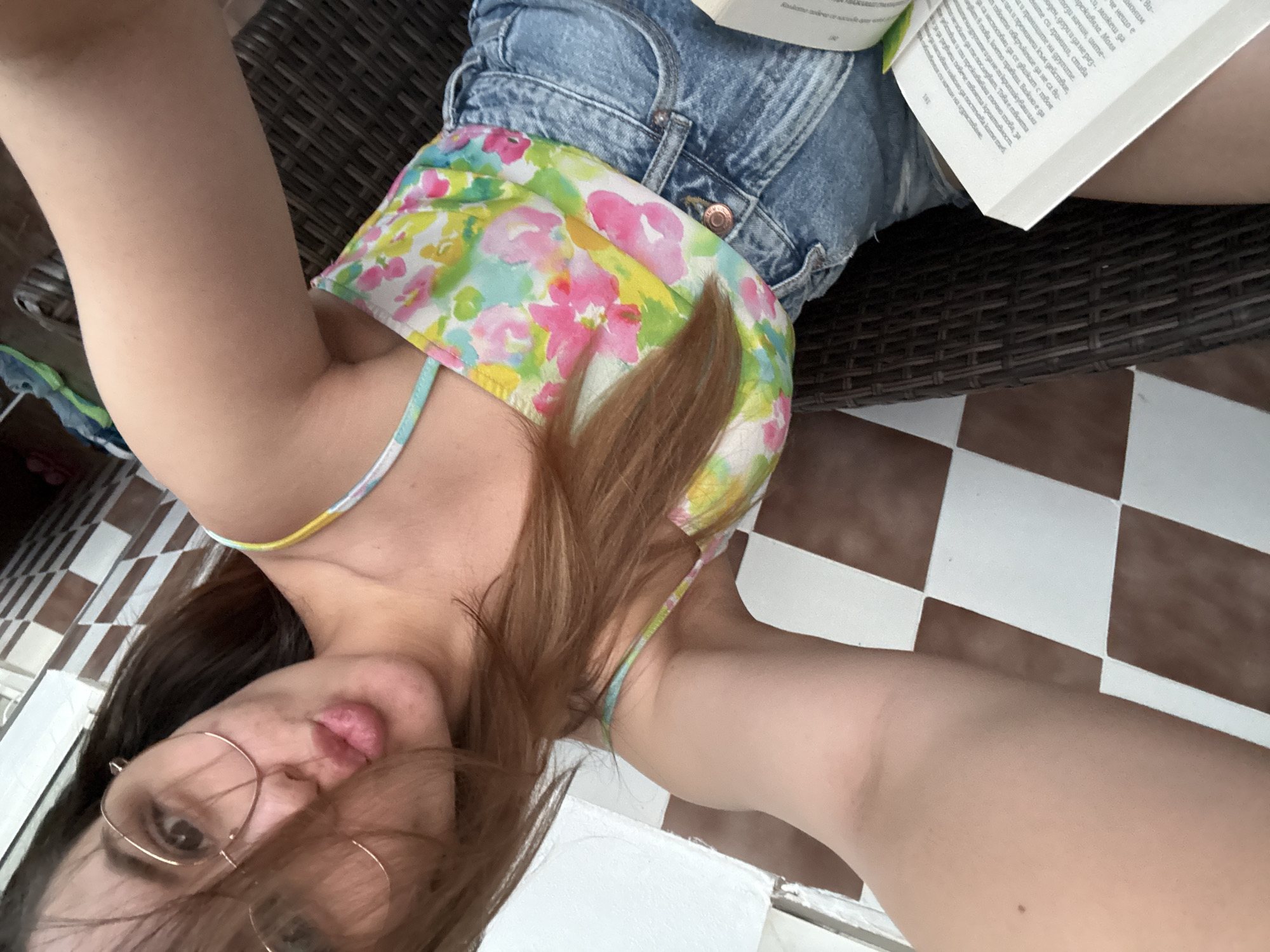 Woman reads self-help book on Sofia balcony, takes selfies