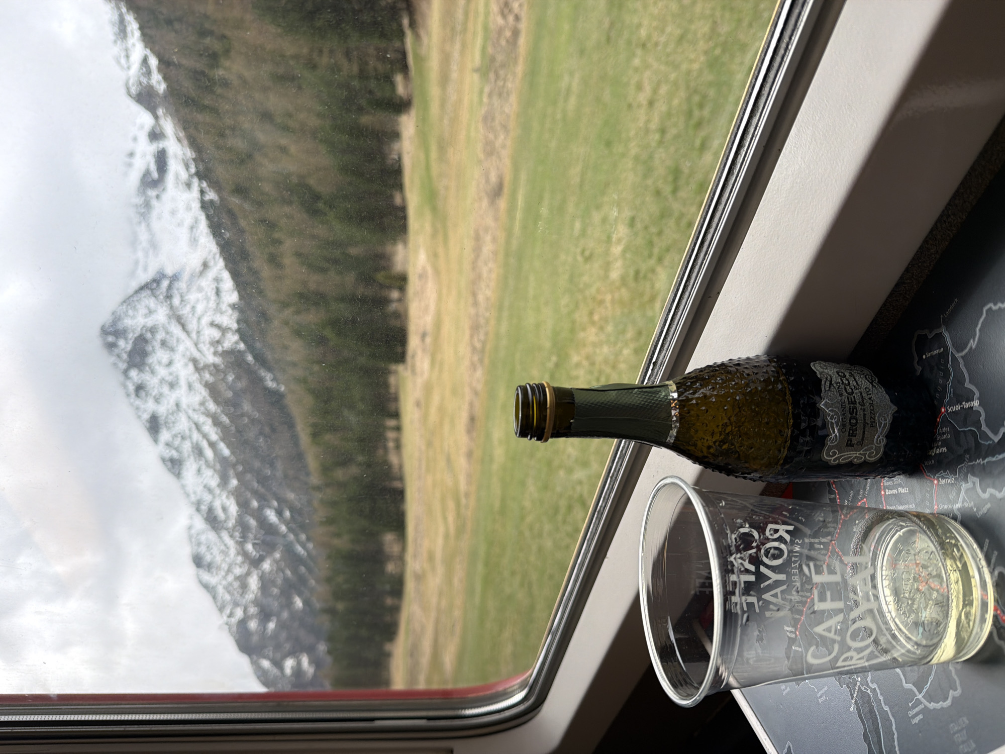 Train passenger enjoys Prosecco amid Swiss Alpine scenery