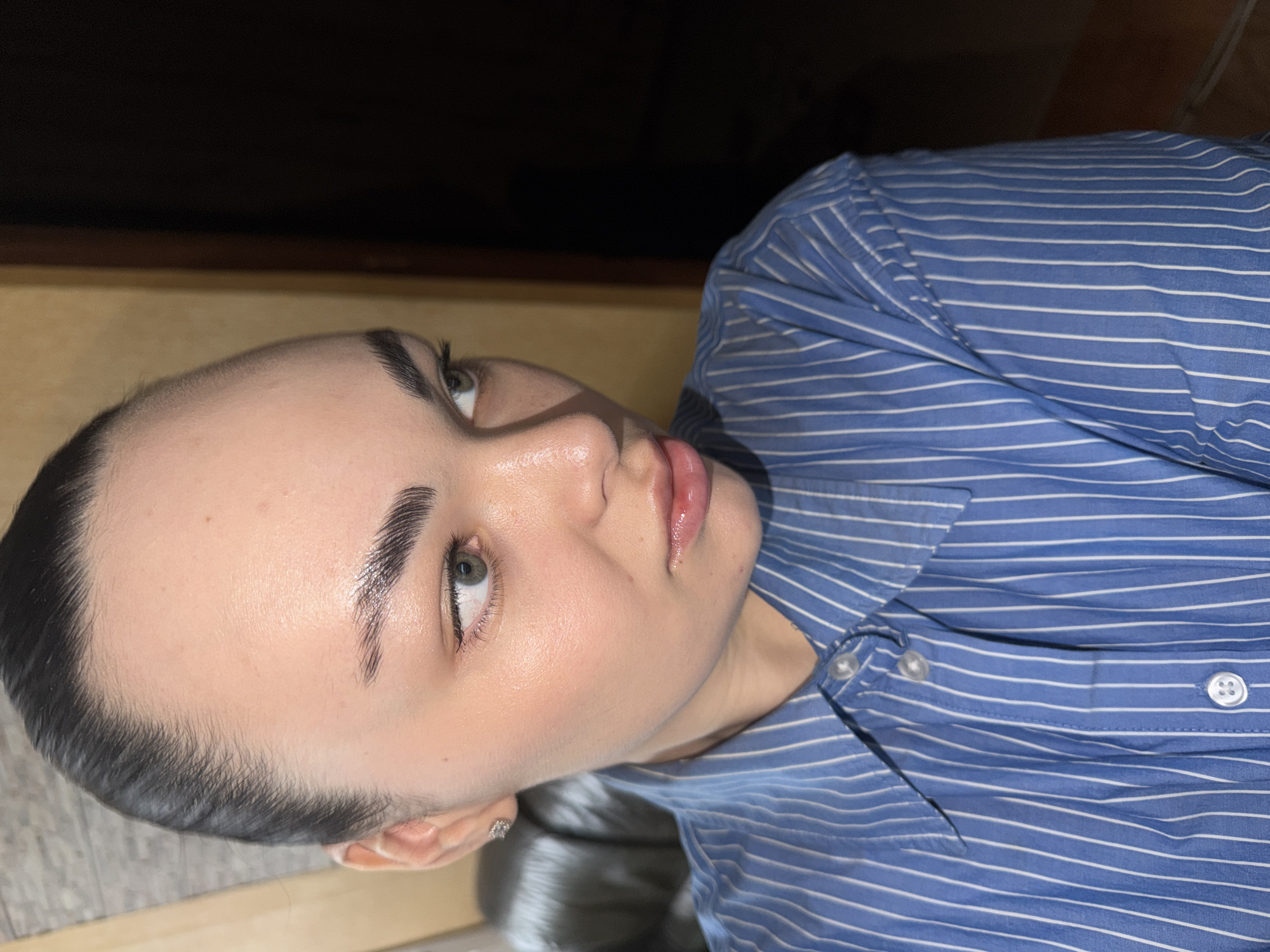 Woman in striped shirt observed looking upward in Perm