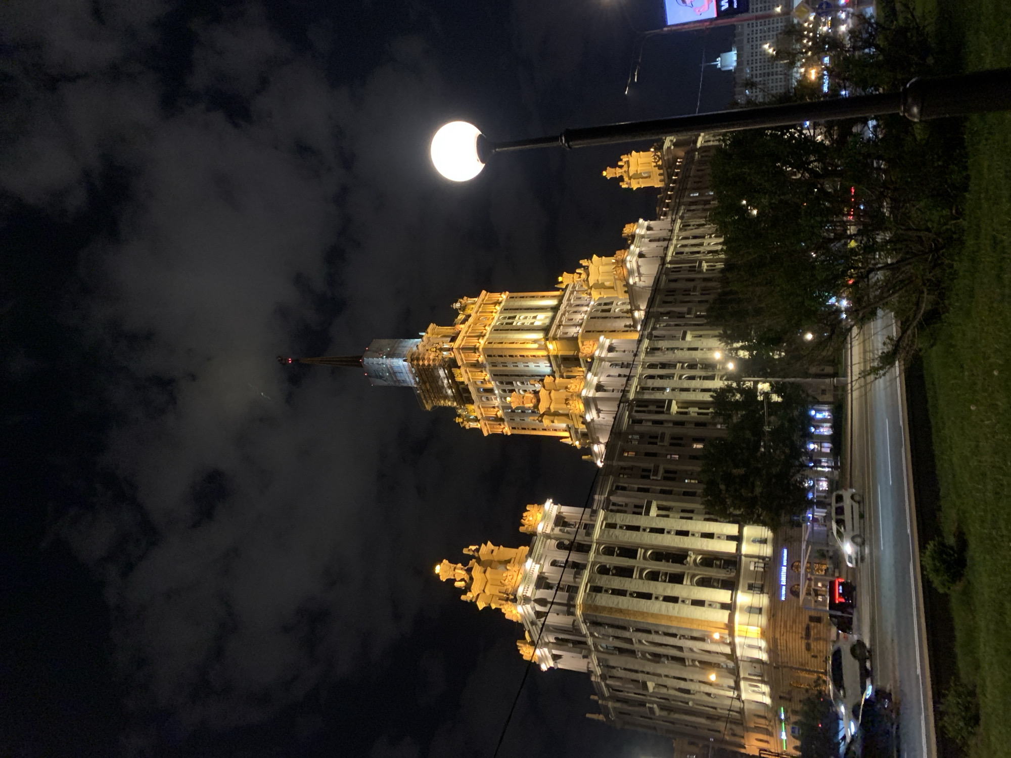 Illuminated spired building photographed in urban nighttime scene