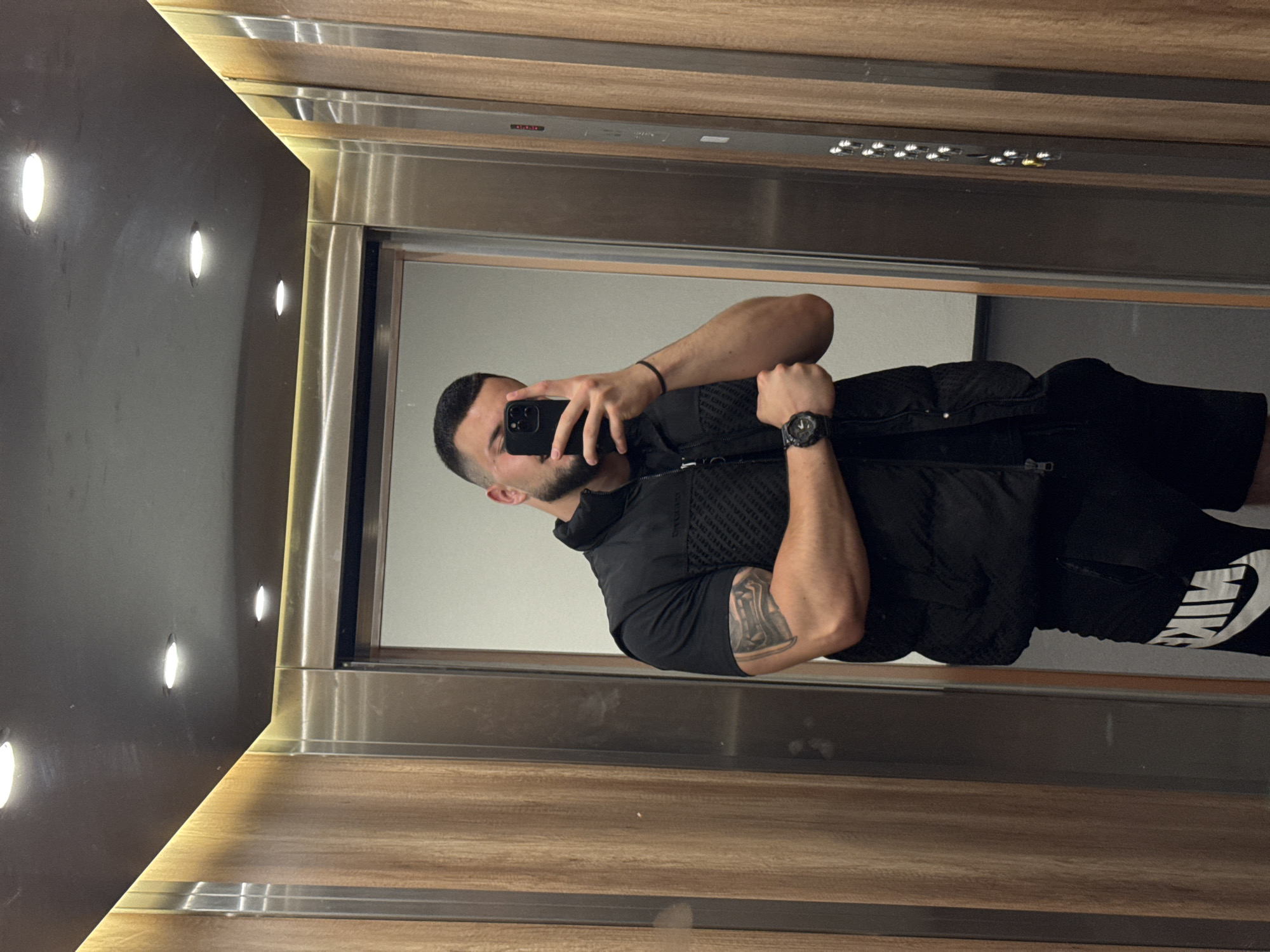 Mirror and direct selfies in a wood-paneled Sofia elevator