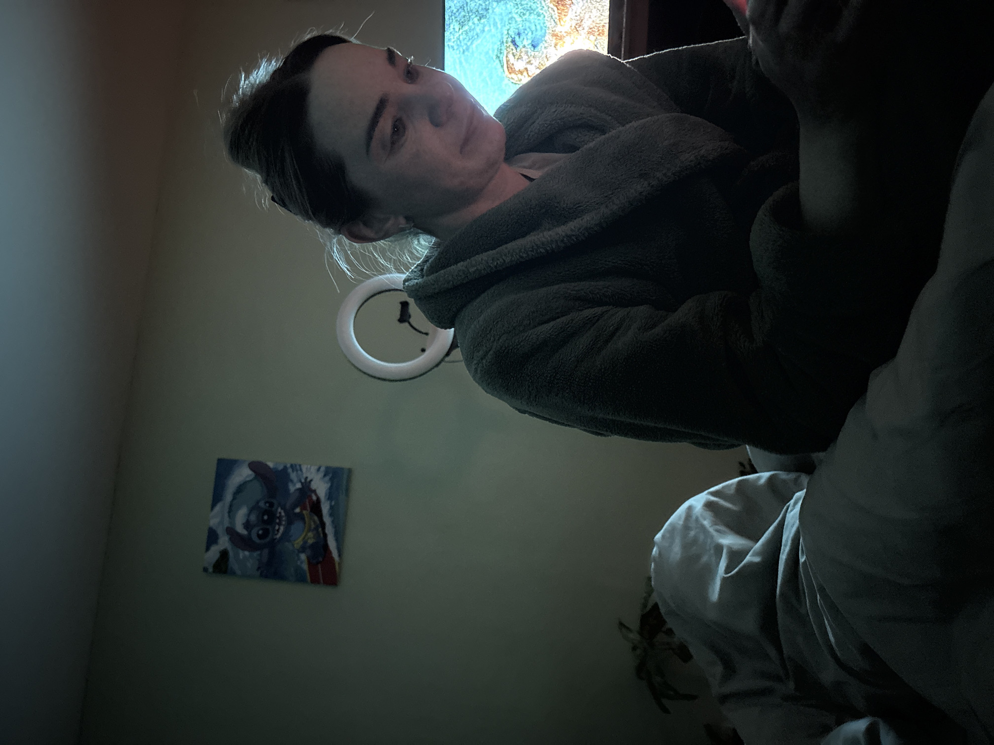 Woman documents late evening smartphone session in Russian bedroom