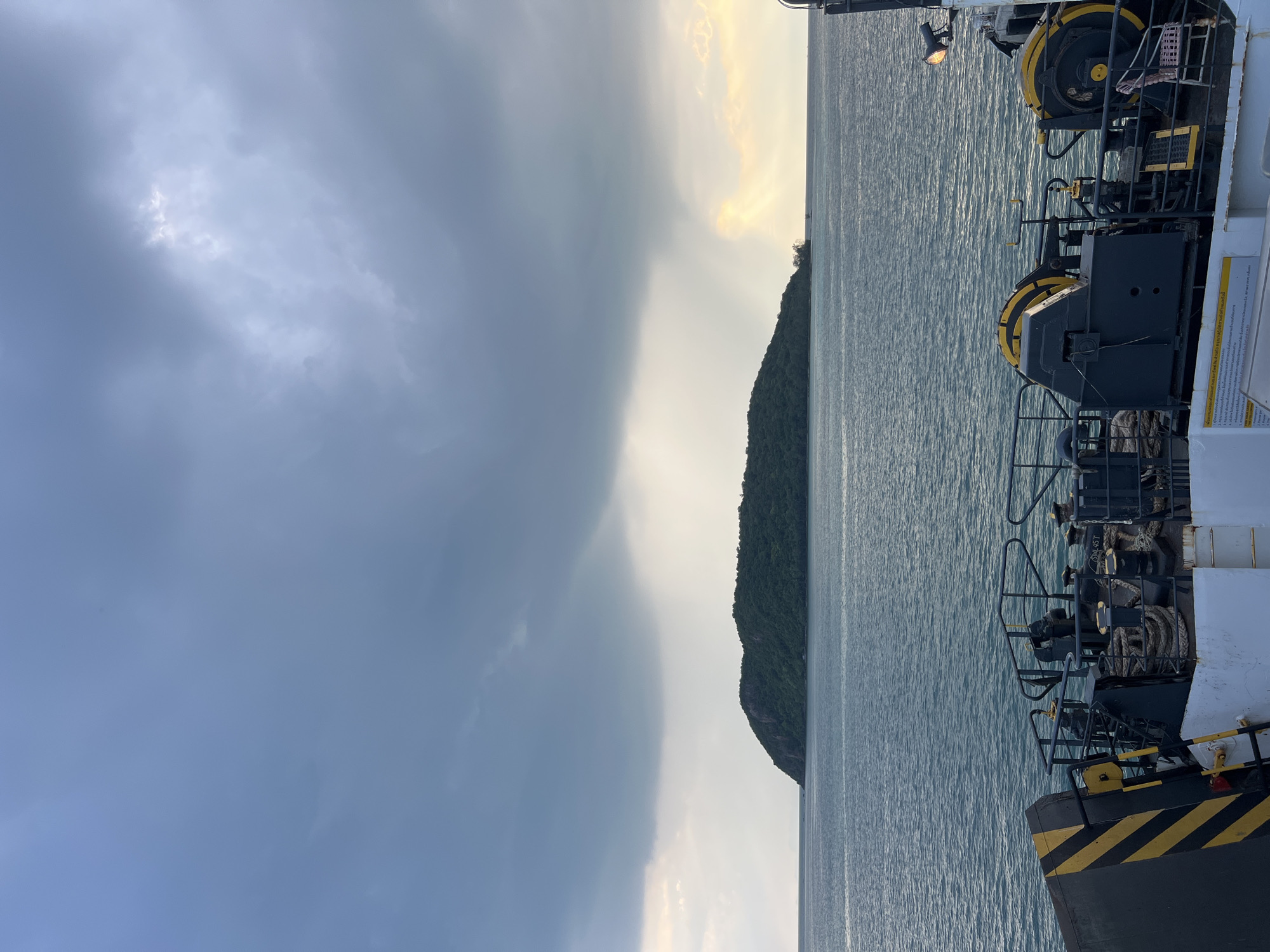Ferry terminal activity near a tropical island, mid-morning