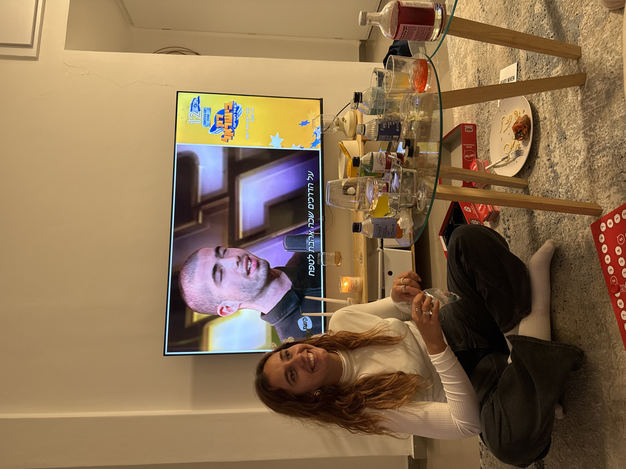 Woman relaxes watching TV in Tel-Aviv home