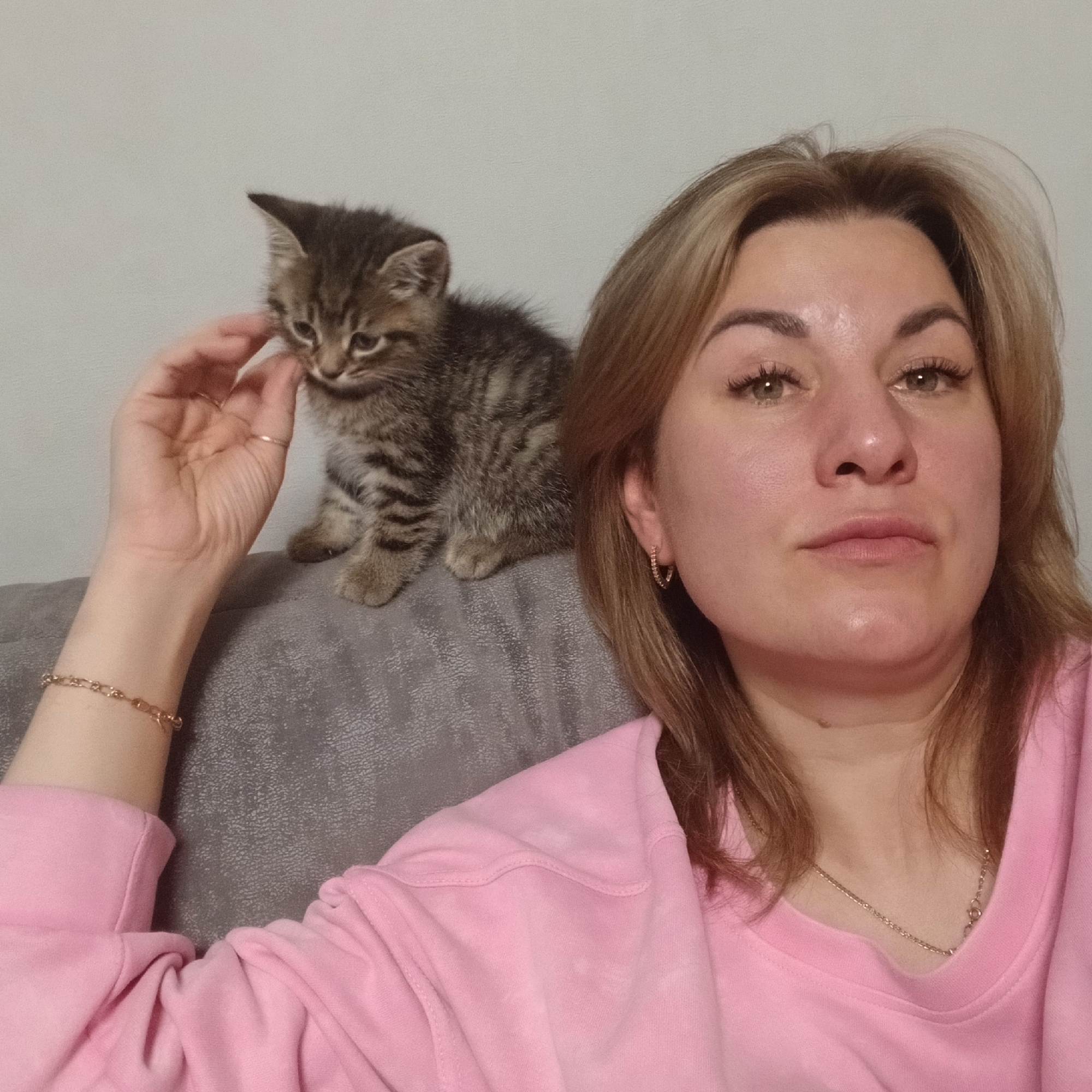 Woman plays with kitten in Izhevsk home