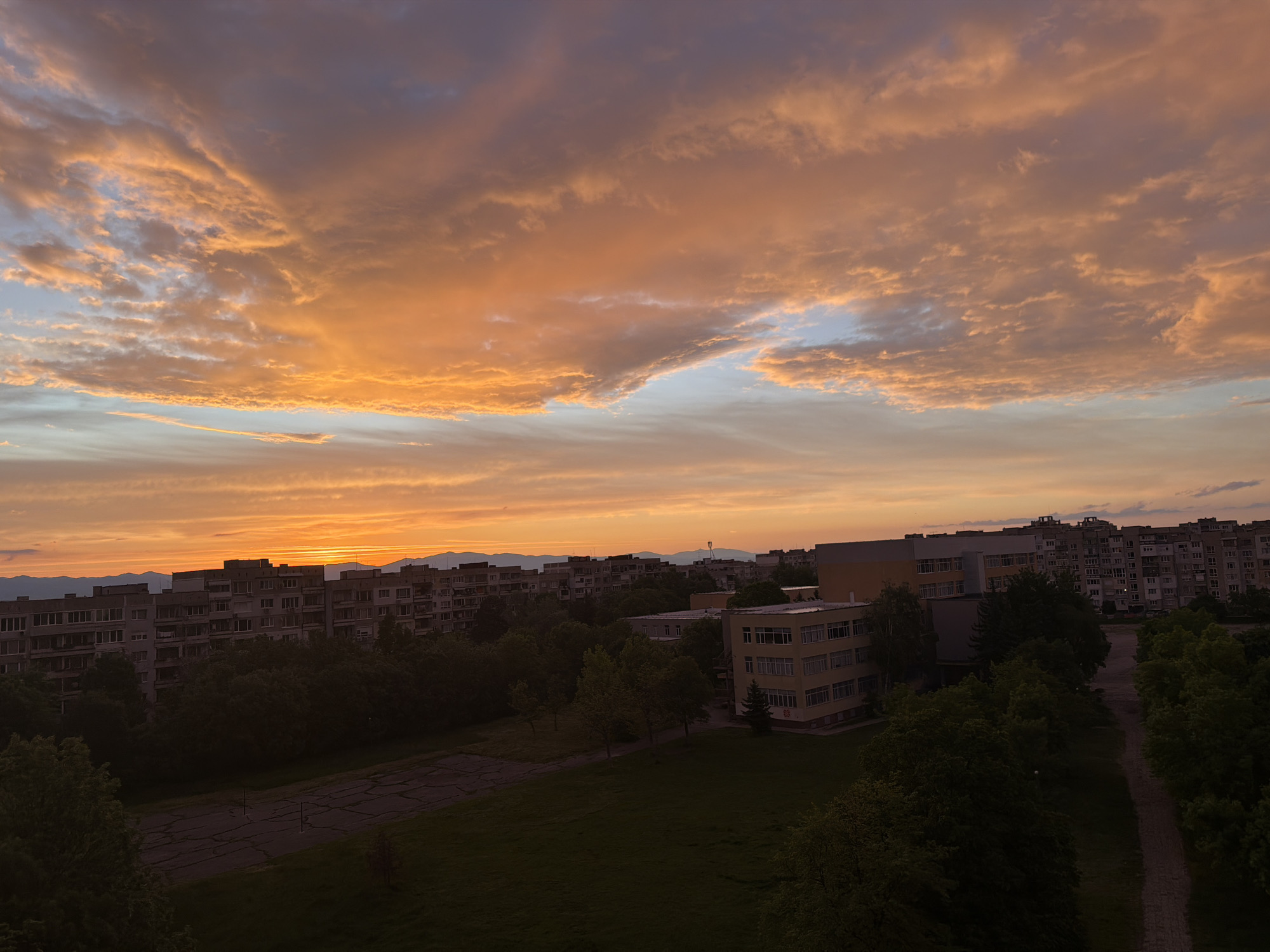Sunset observed over city with orange yellow clouds