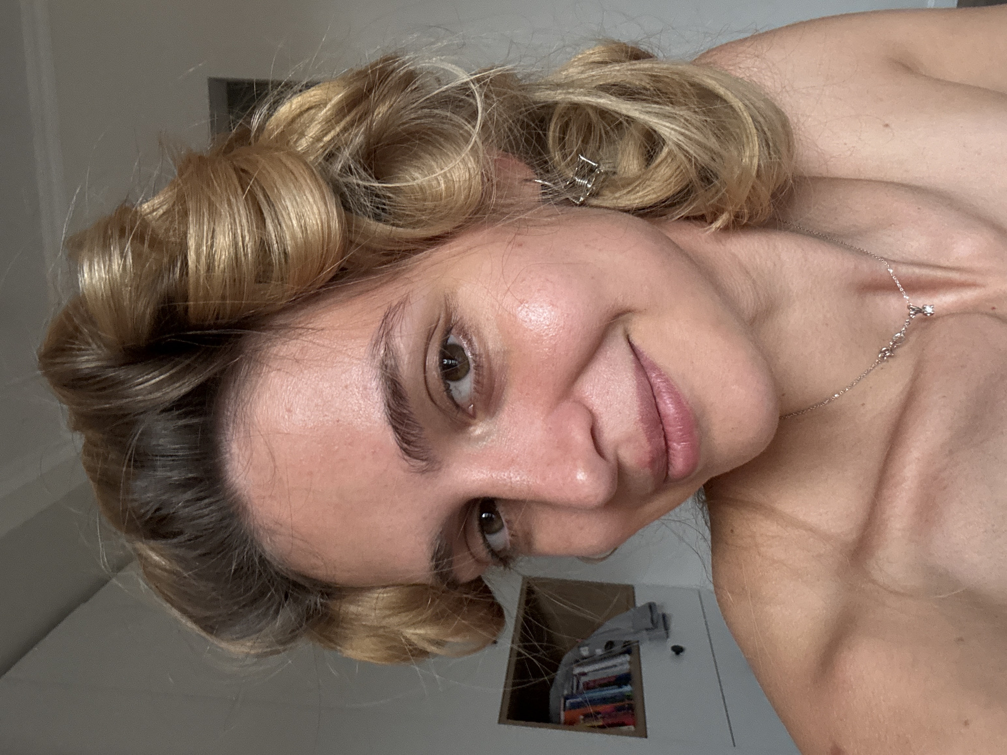 Blonde woman photographed in indoor portrait session with styled curls