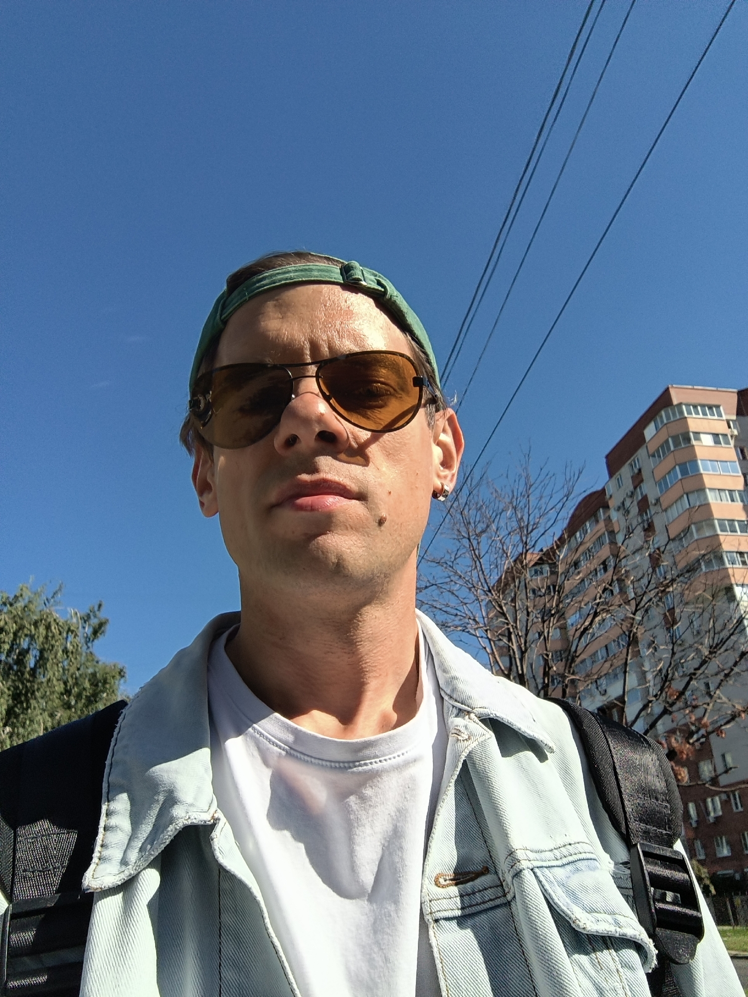 Casual outdoor selfie with a layered summer street look