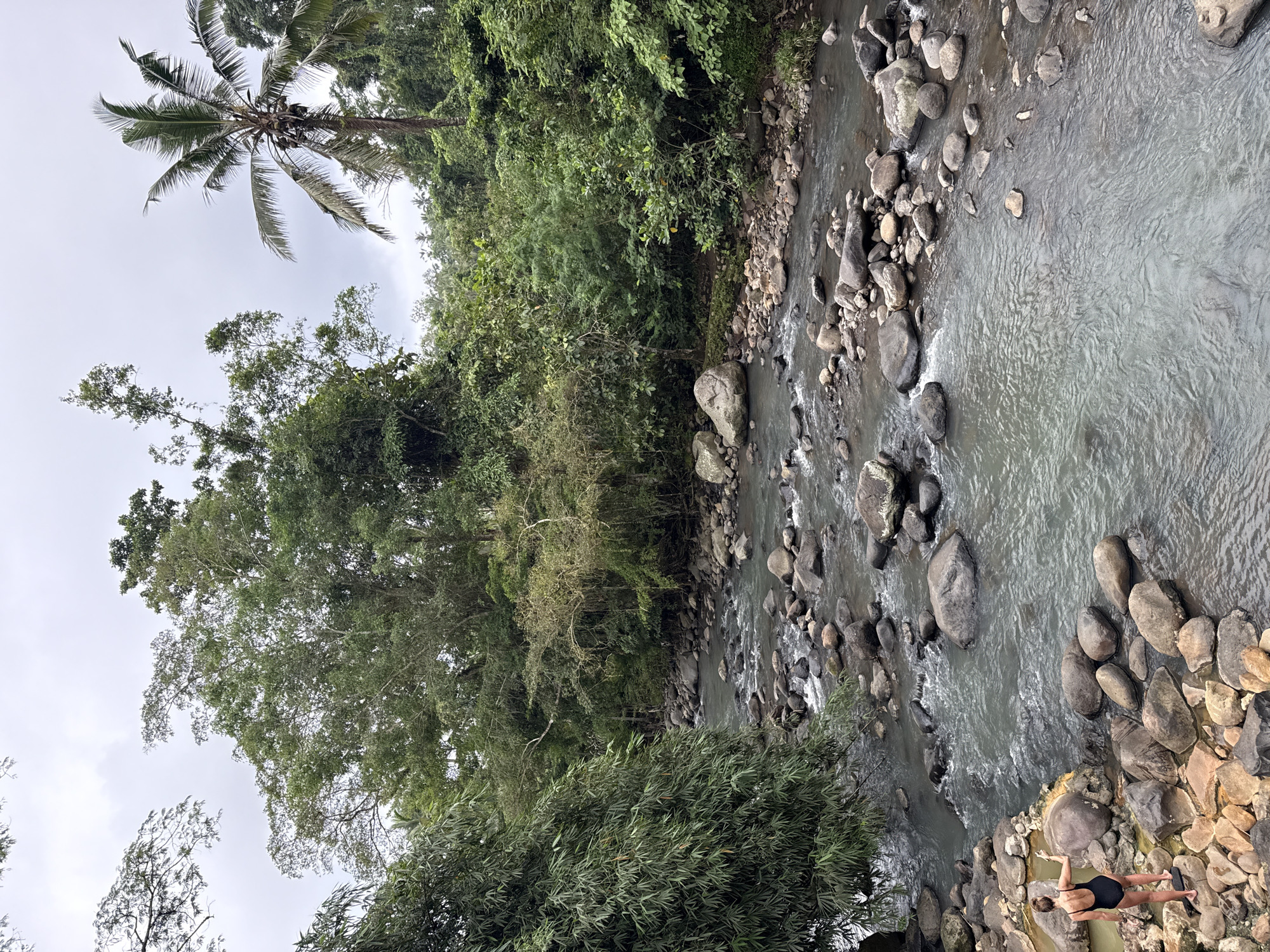 Rocky river flowing through dense vegetation documented by witness