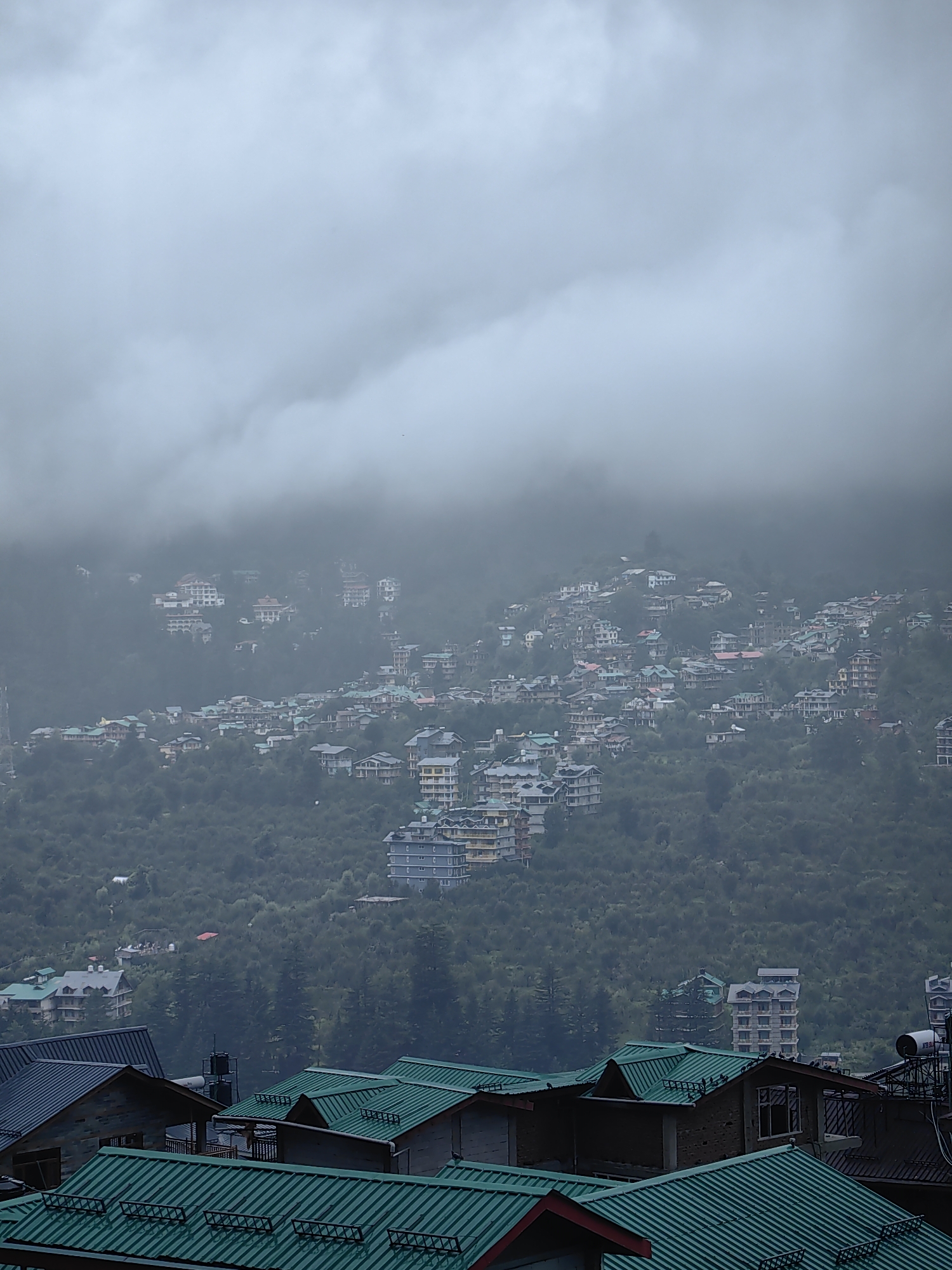 Rainy morning in cloud-covered Vashisht, construction and daily life persist