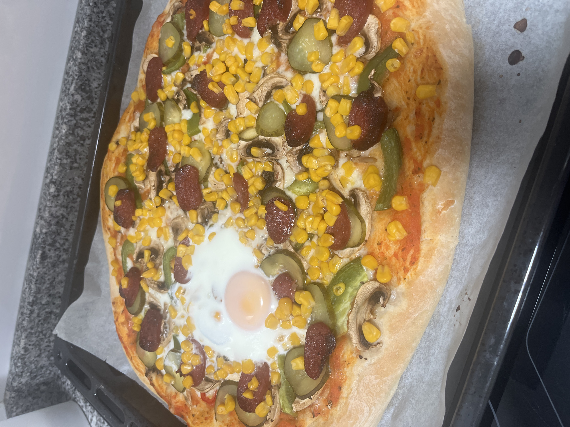 Homemade pizza with unusual toppings documented in Mogán, Spain