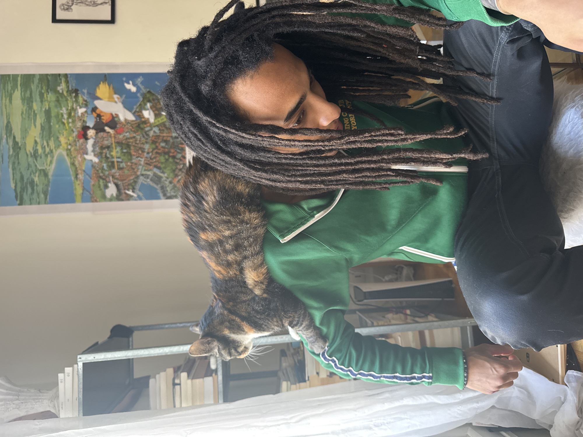 Person with dreadlocks shares quiet moment with cat in Paris