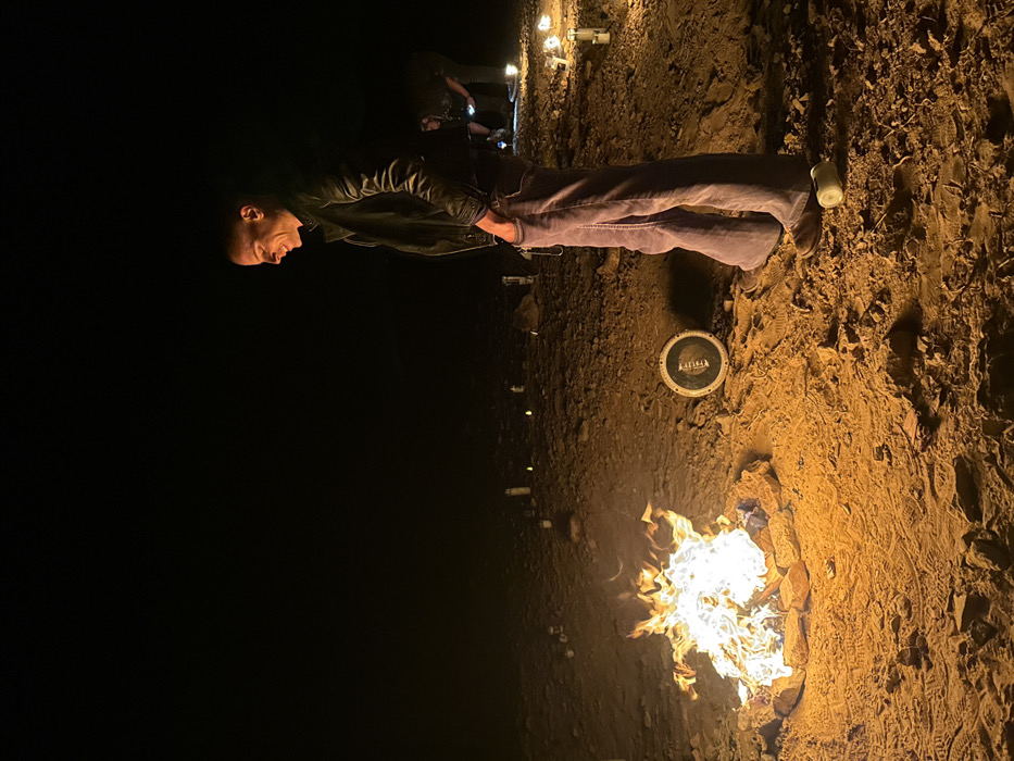 Man tends multiple campfires in Mizpe Ramon desert area