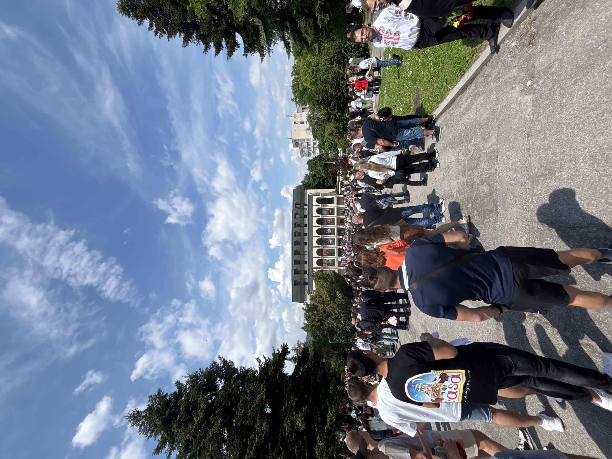 Crowd gathers in plaza outside multi-story building