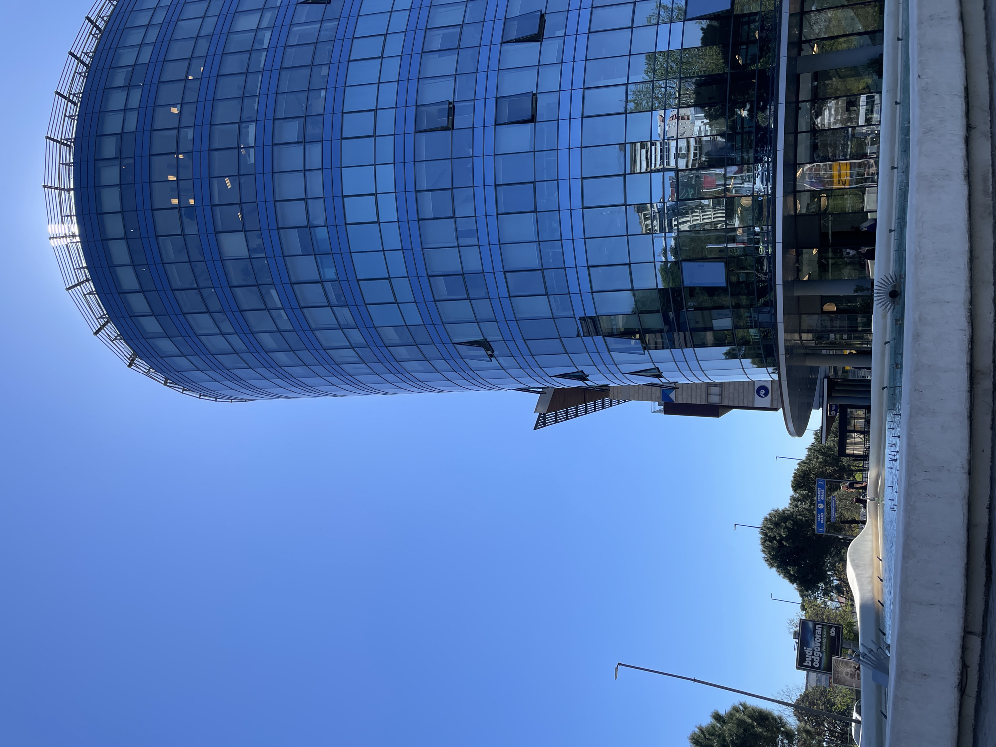 Modern curved blue-glass building observed in Podgorica, Montenegro