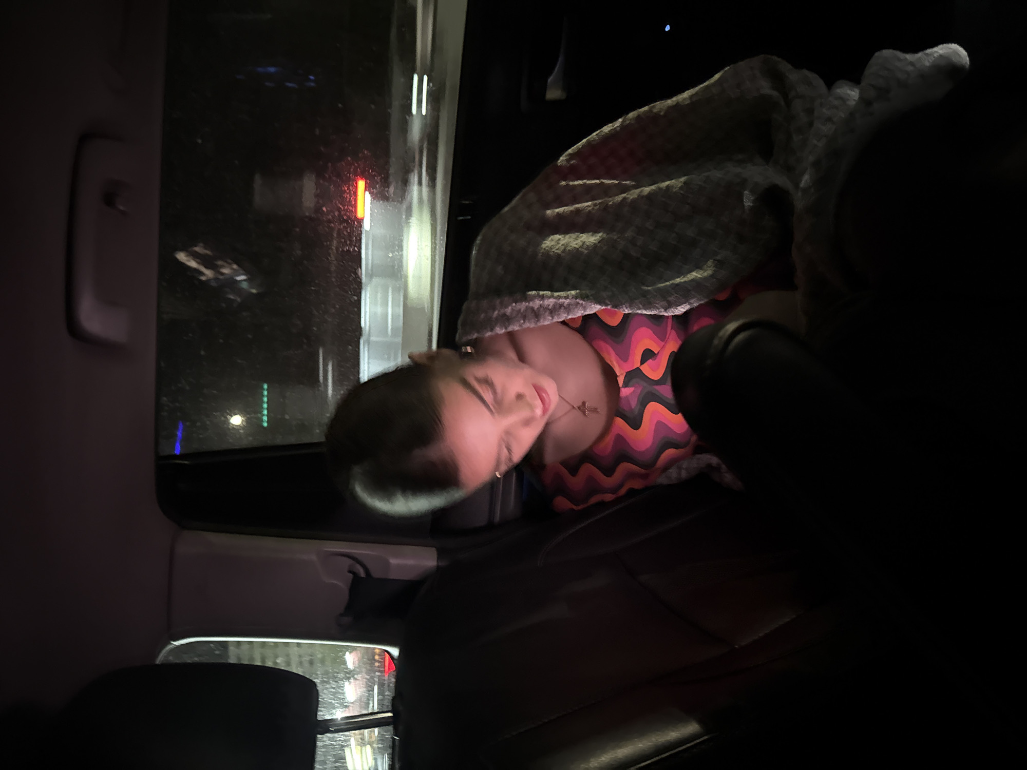 Person sleeps in vehicle back seat in Armenian city