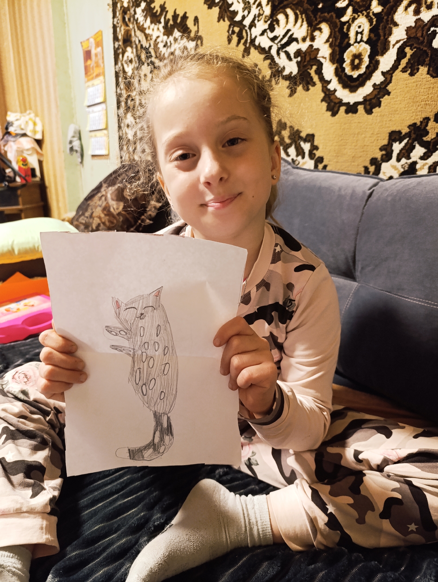 Young girl creates art at home with cat nearby