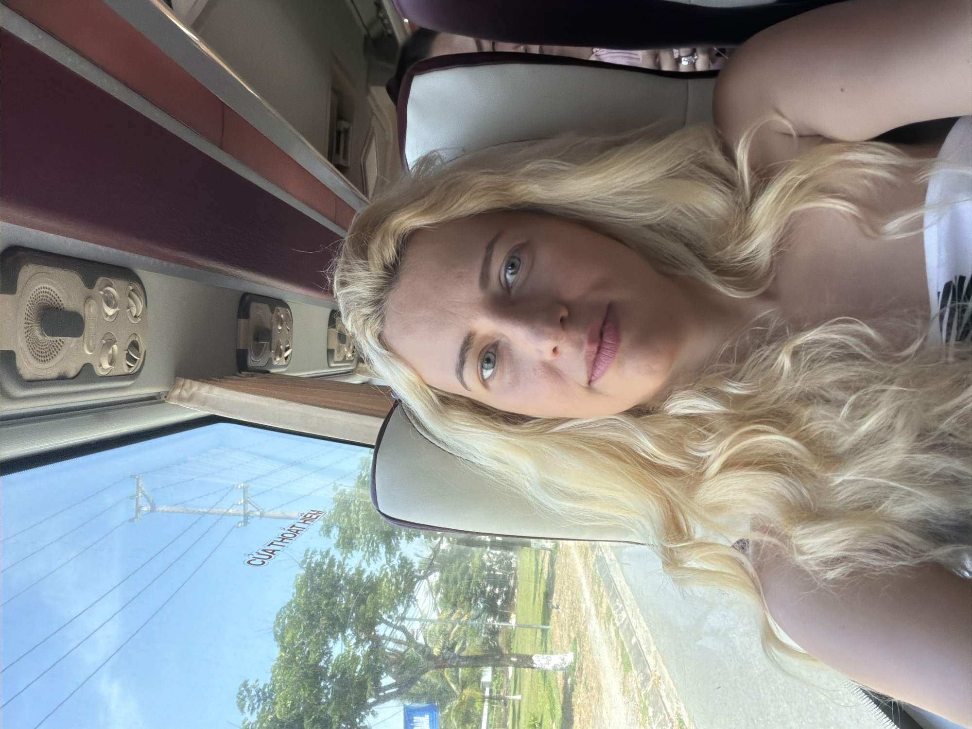 Blonde woman rests on bus seat in Đà Nẵng