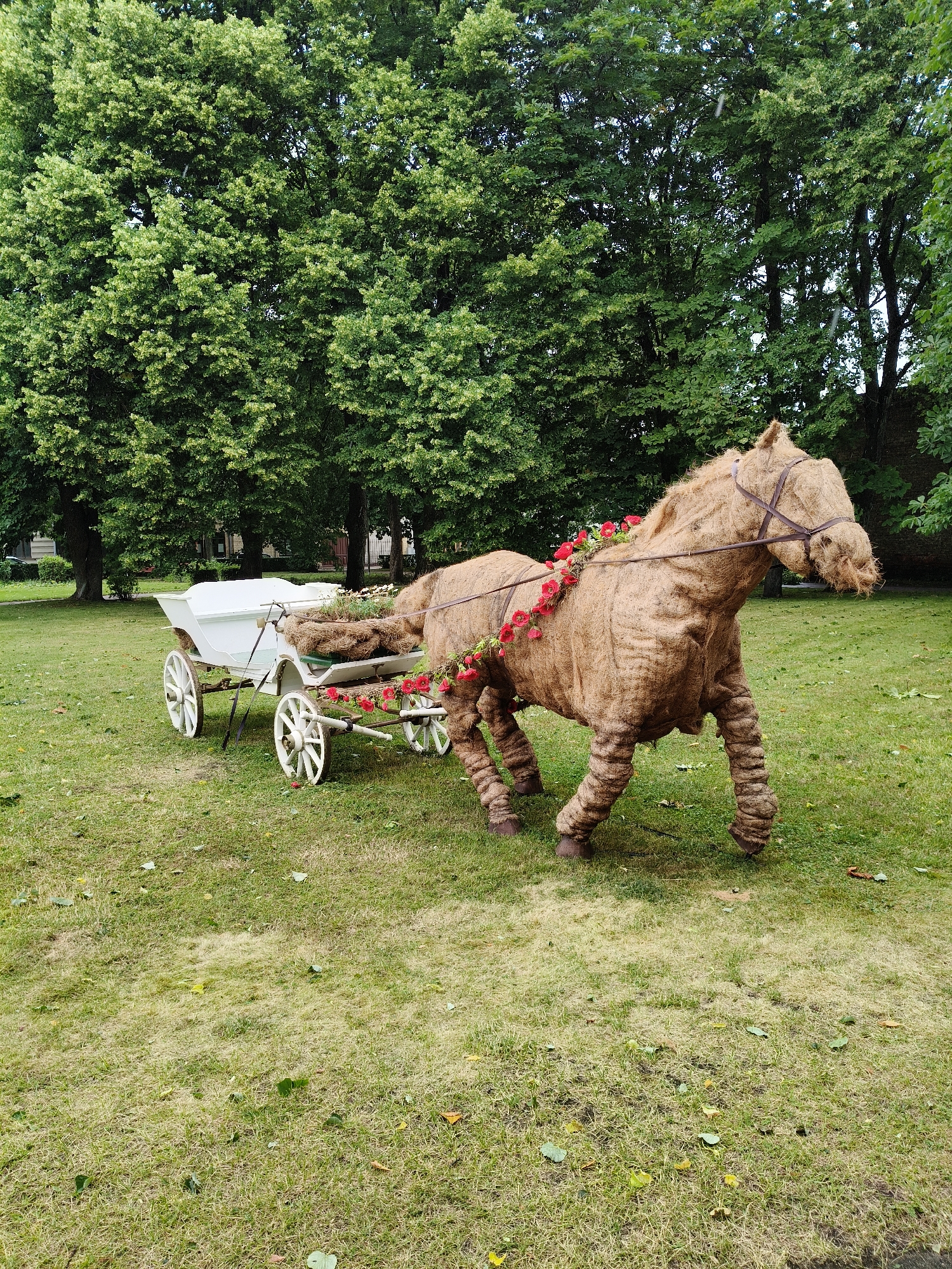 Straw horse sculpture with floral decorations in Ventspils