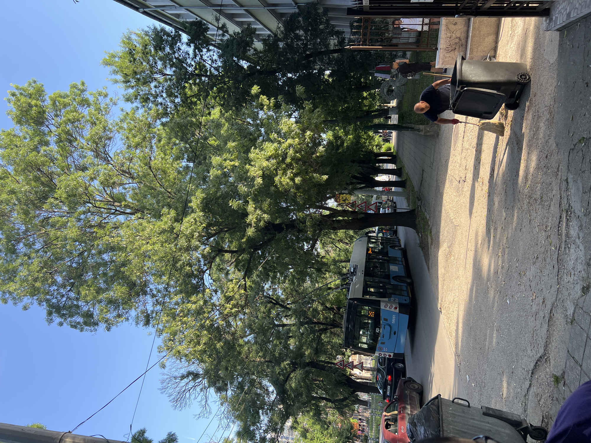 Street cleaner works as pedestrians gather on city sidewalk
