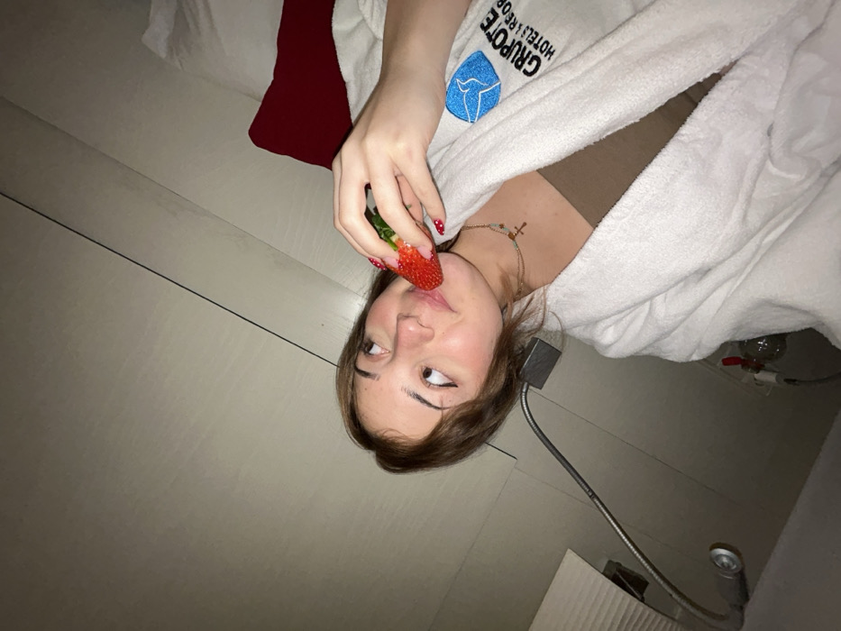 Woman poses with strawberries in Spanish hotel room