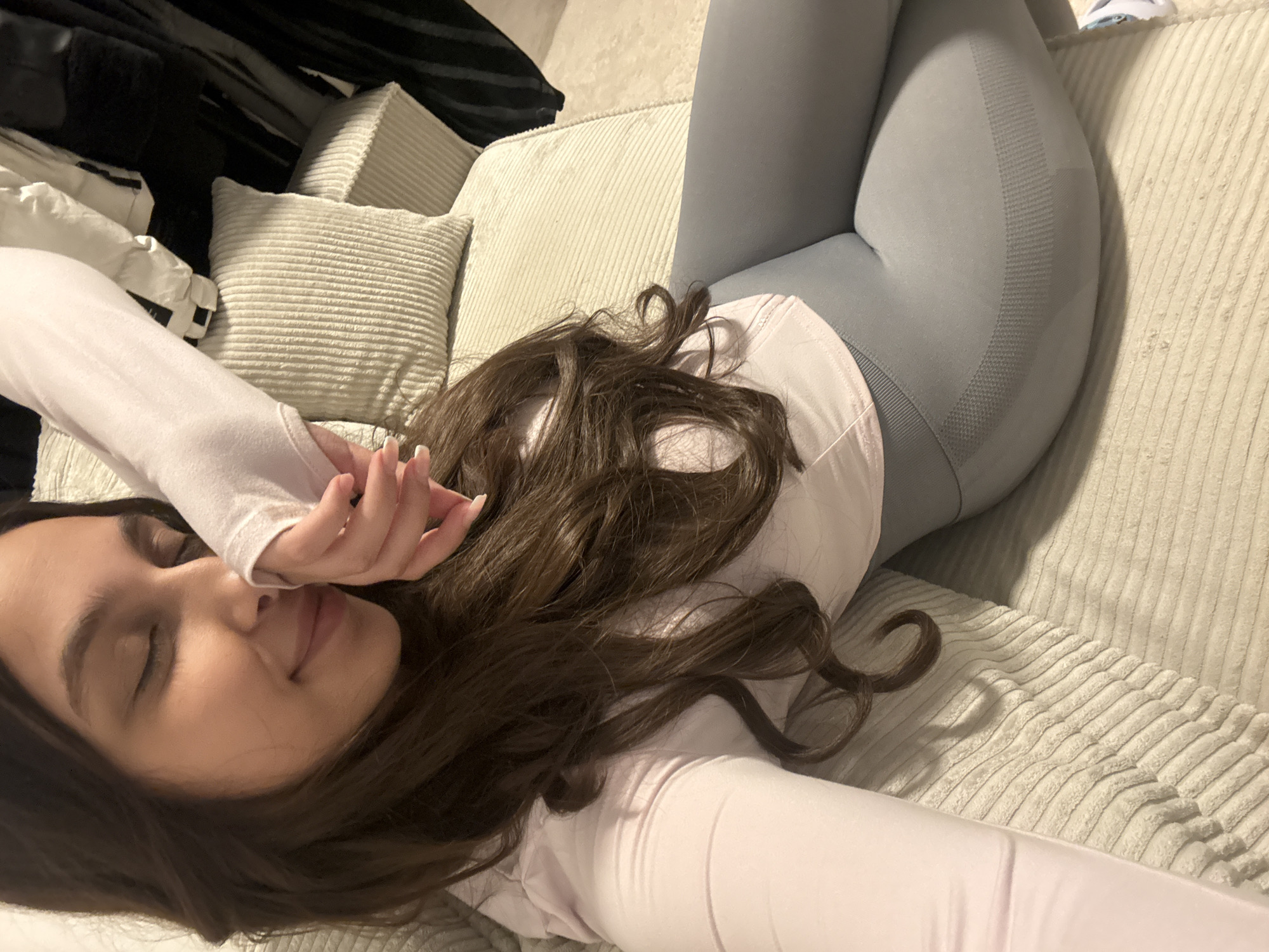 Woman rests on couch in Mönchengladbach home setting