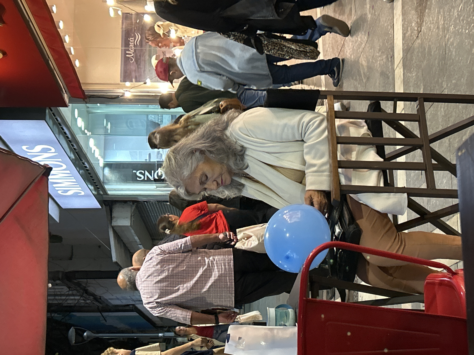 Elderly woman seated on Córdoba street late evening