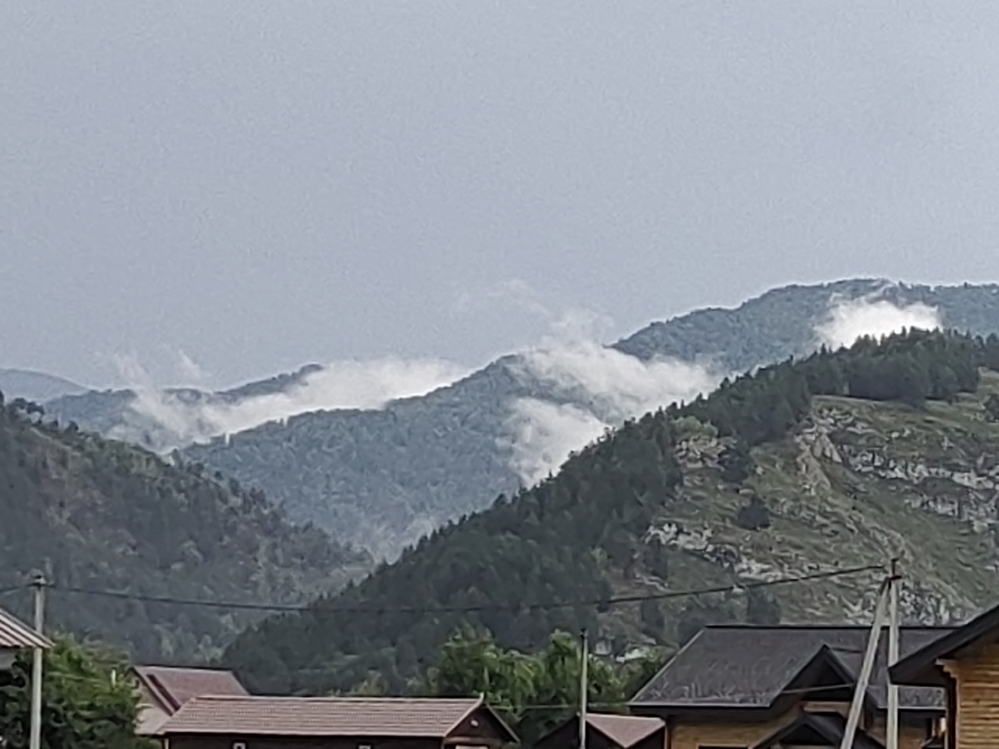 Misty mountain village in Anos, Russia on a cloudy day
