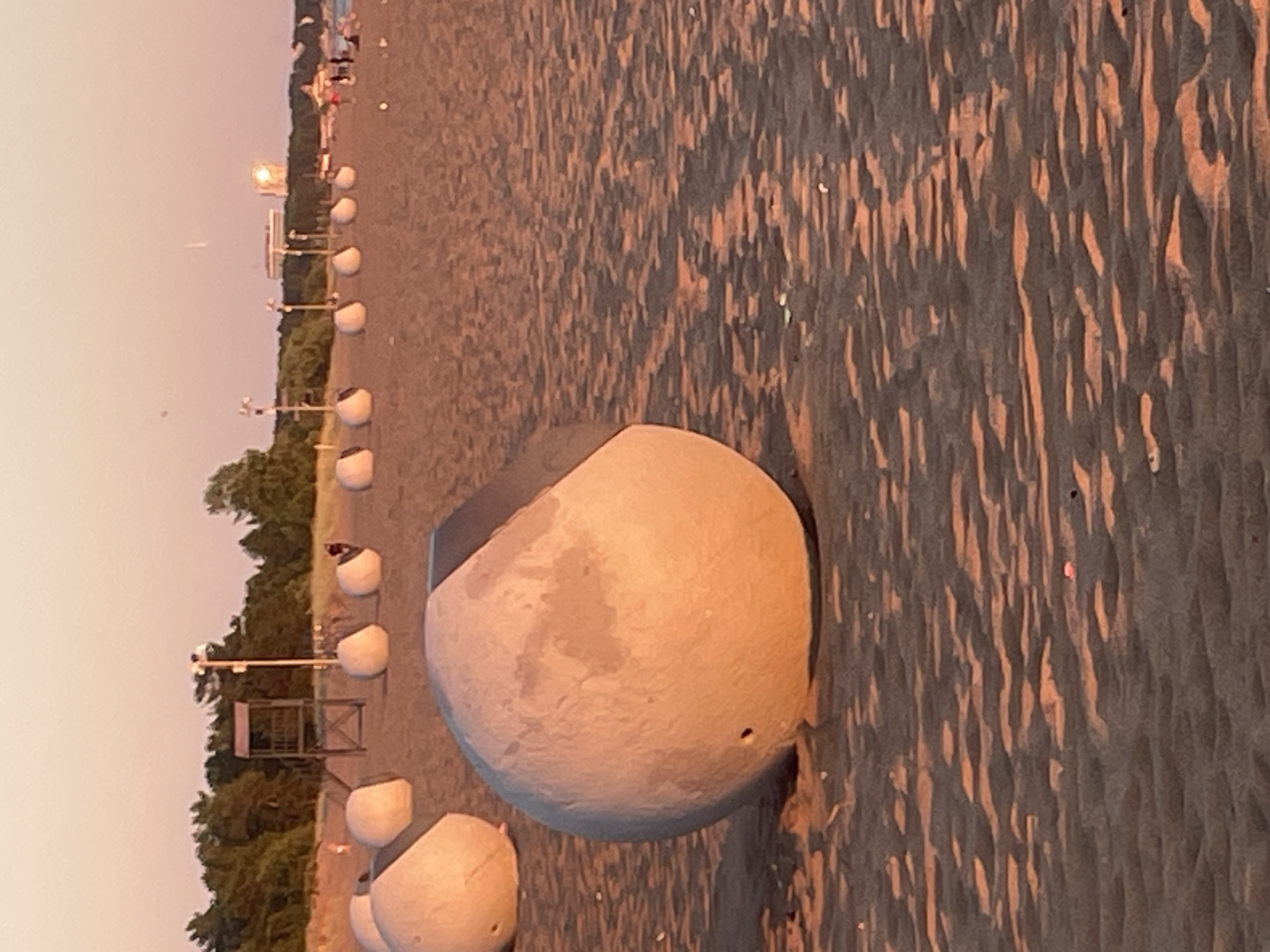 Sunset evening at Solnechnoye beach, swimmers and strollers out