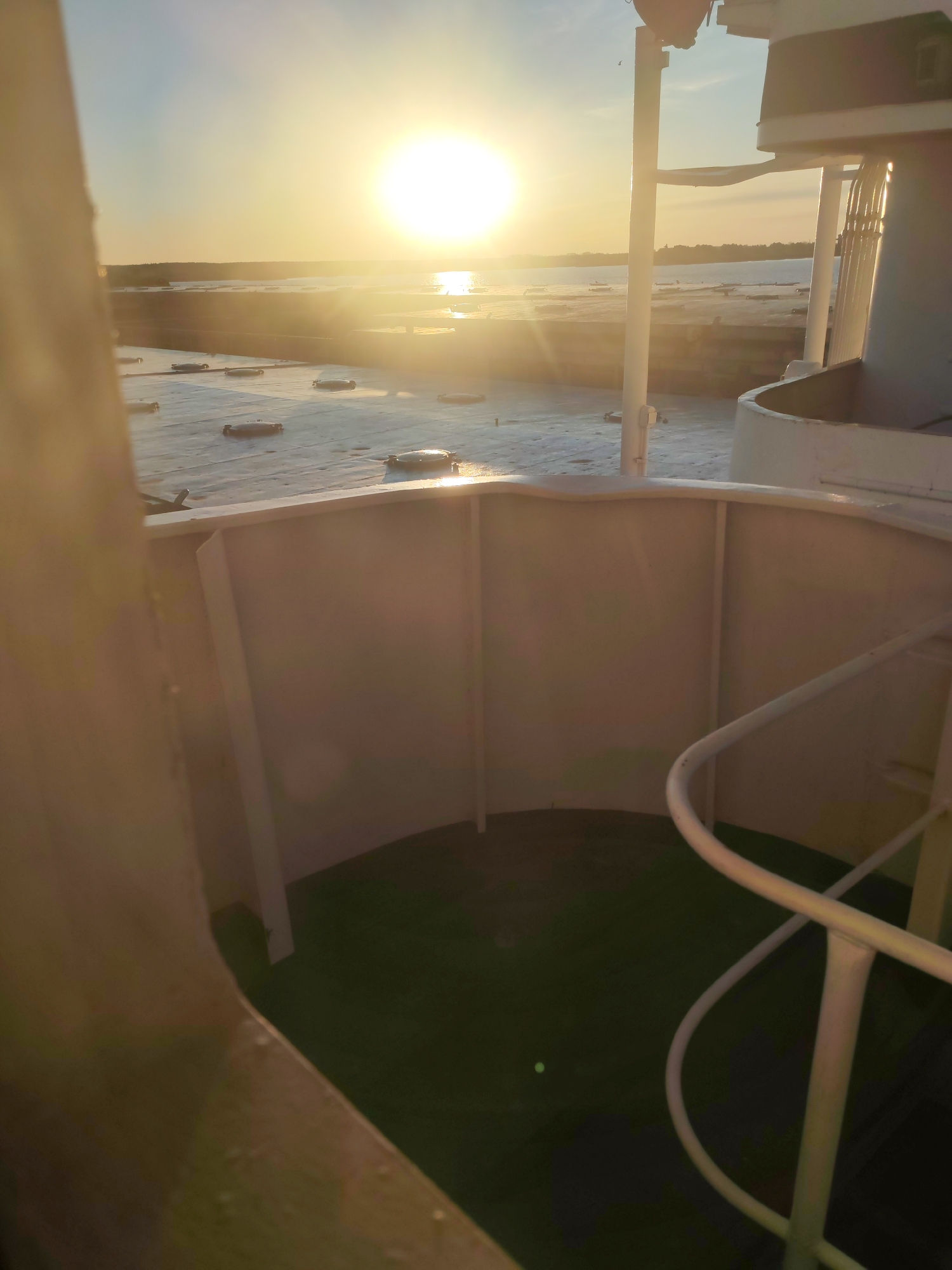 Golden sun observed over water from elevated structure
