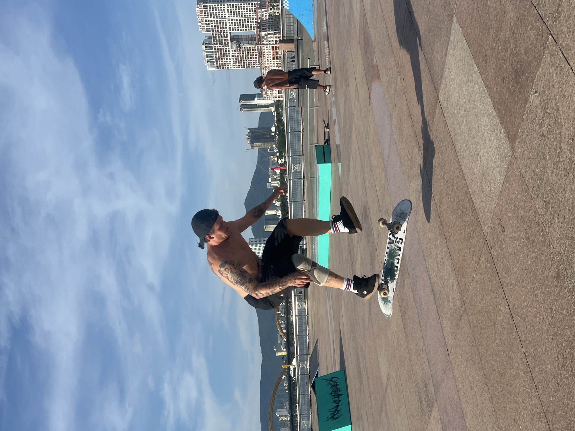 Smoke rises over Đà Nẵng as skateboarder sessions the riverside
