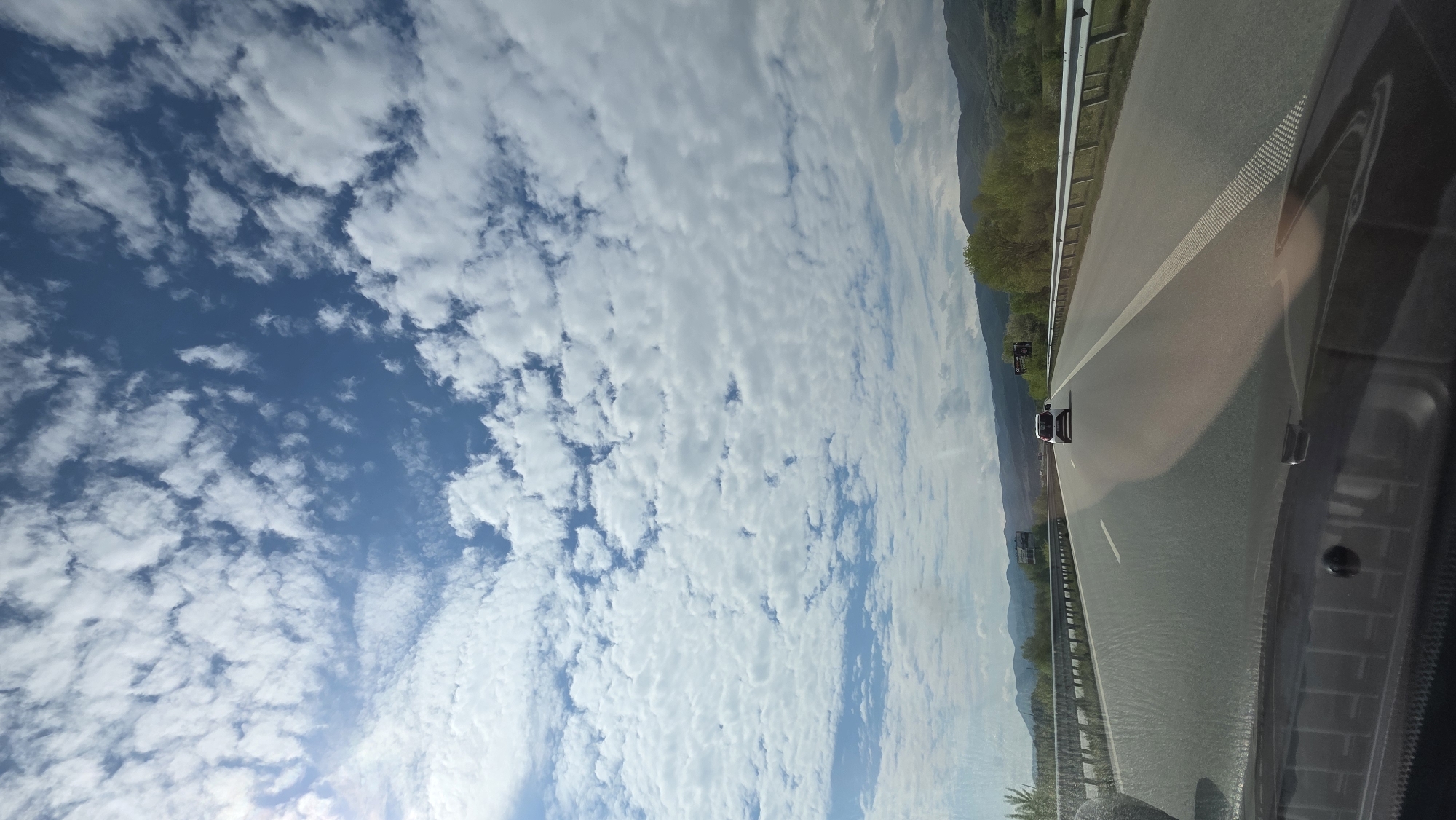Vehicle travels highway near Strumyani, Bulgaria under cloudy skies
