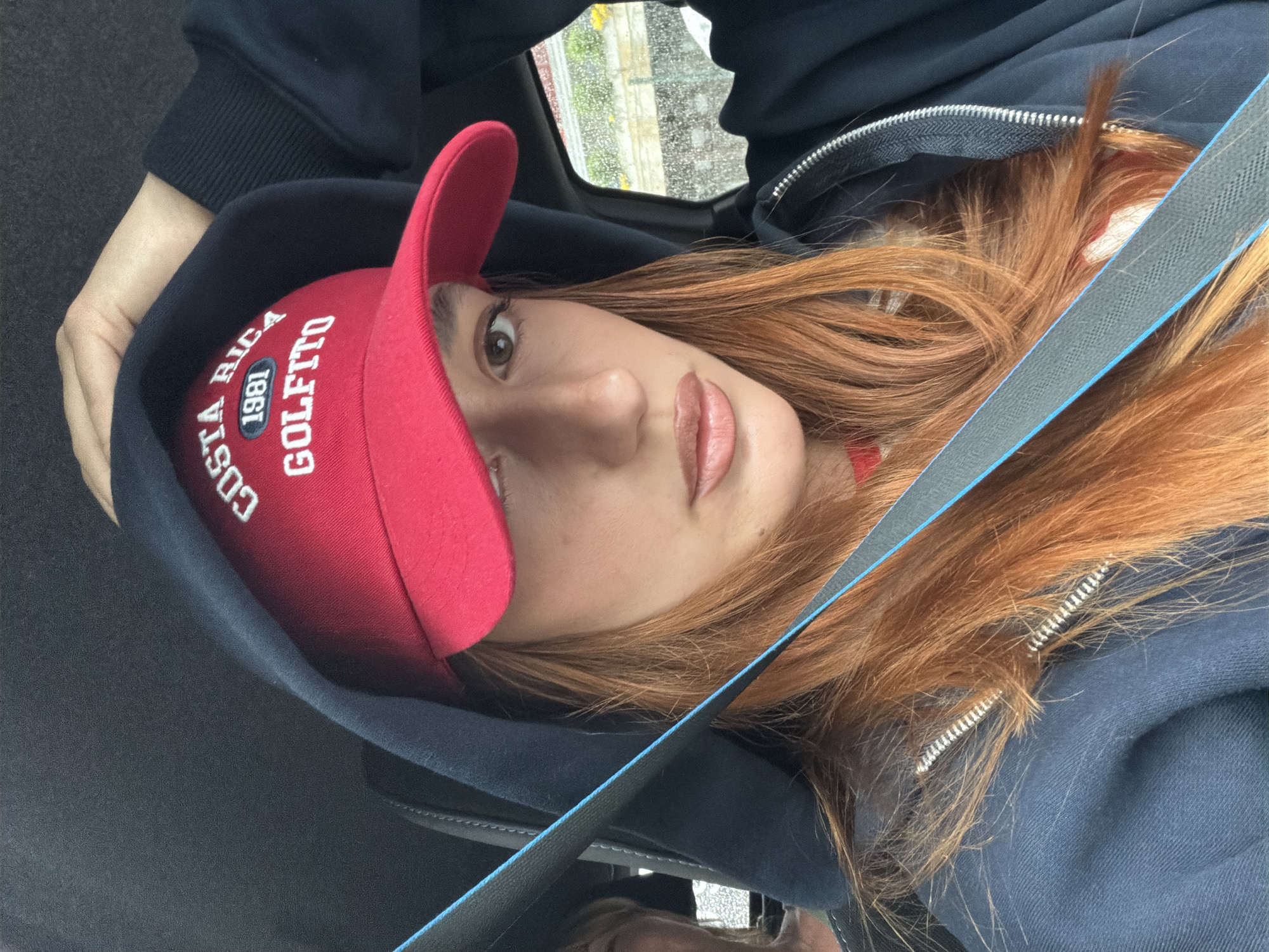 Woman in Costa Rica cap observed in vehicle, Spreitenbach