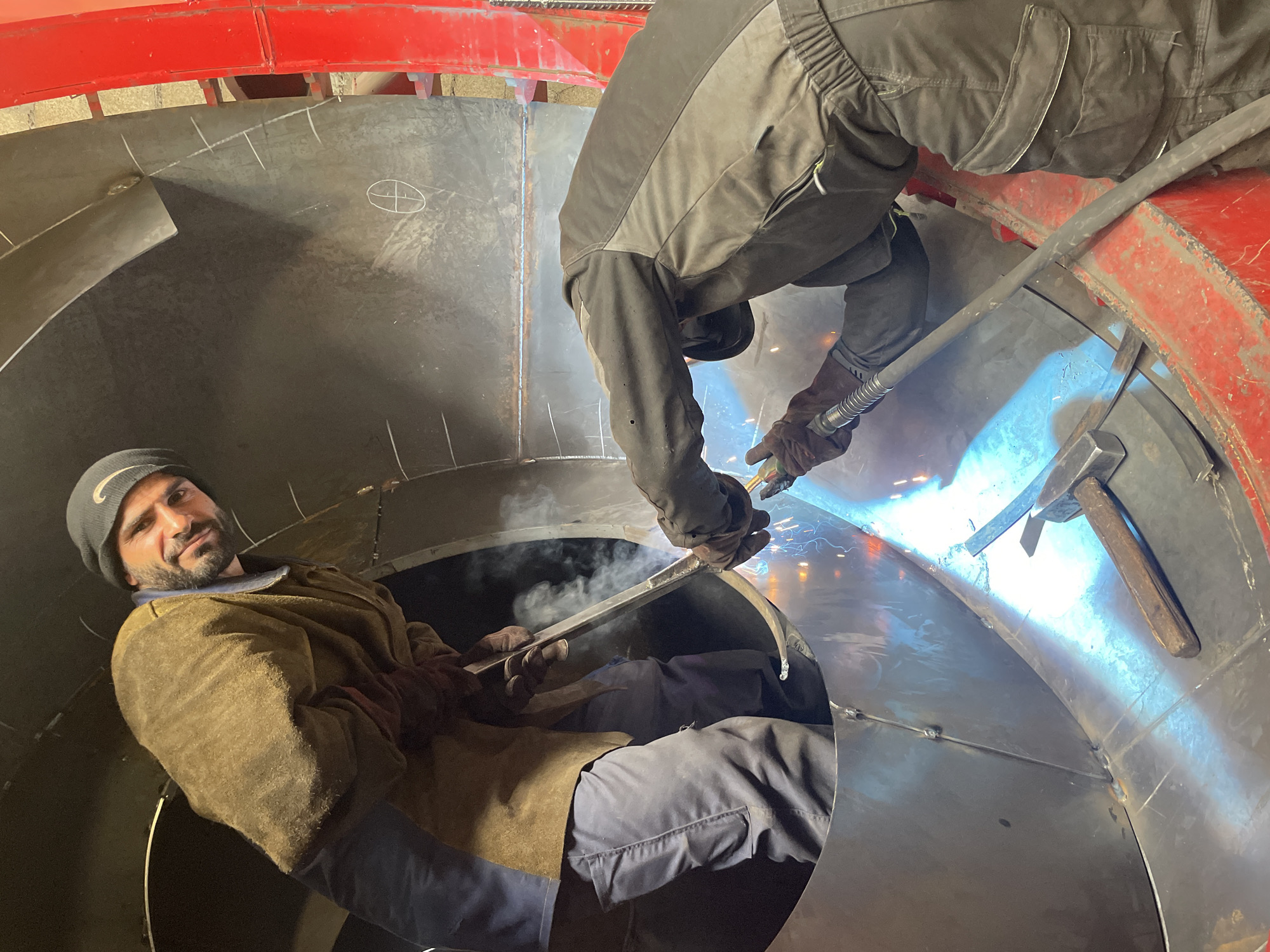 Welders work inside curved metal structure in Montenegro