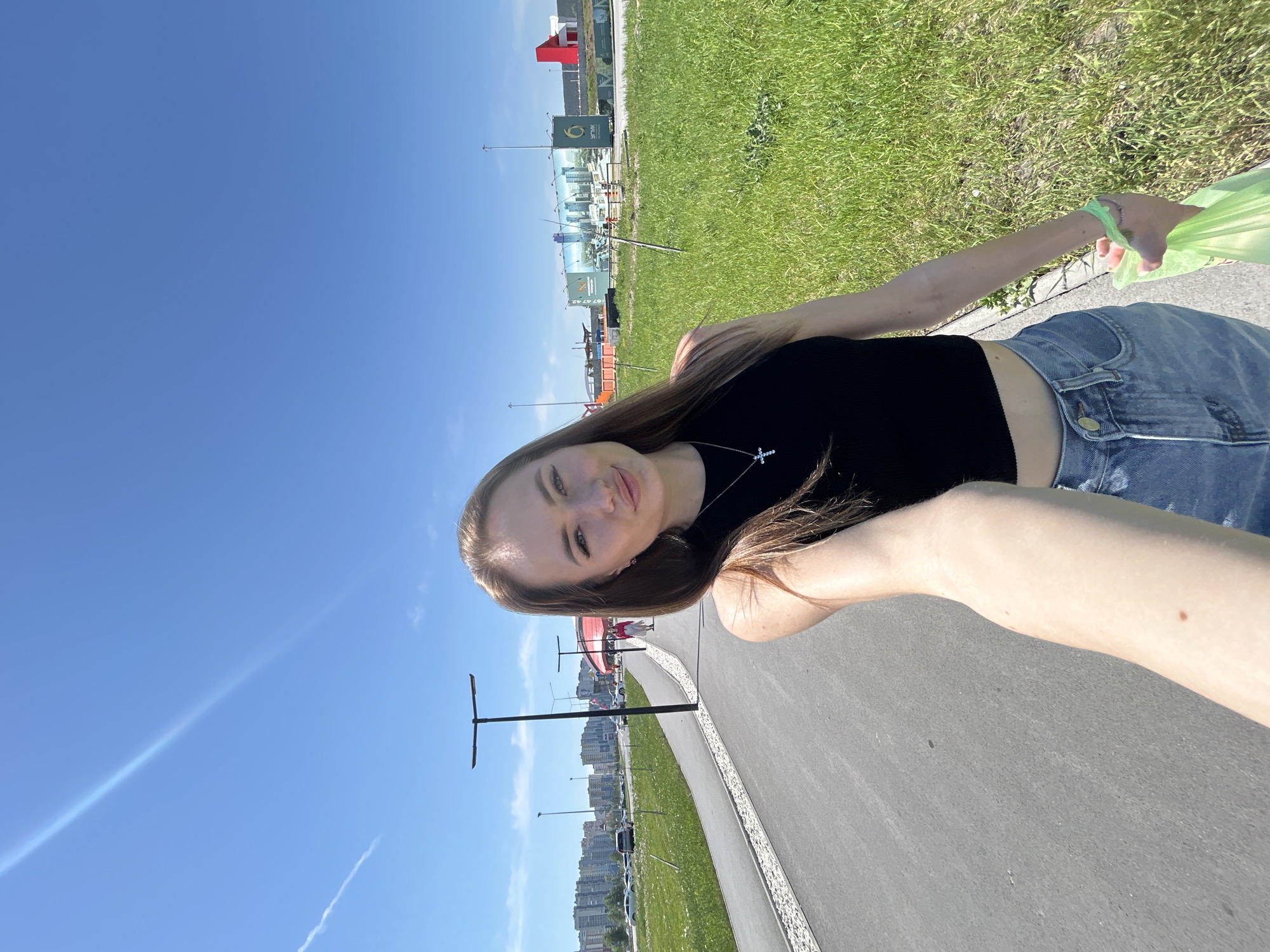 Woman takes selfies in sunny outdoor plaza area