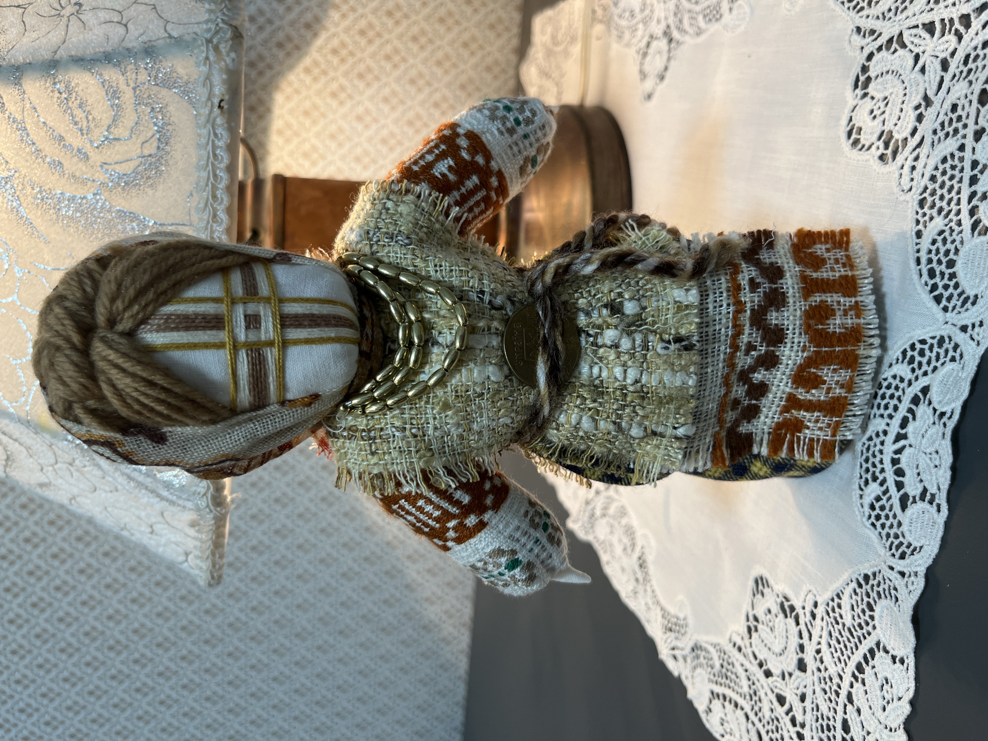 Decorative home objects: folk doll, houseplant, and patterned fabric
