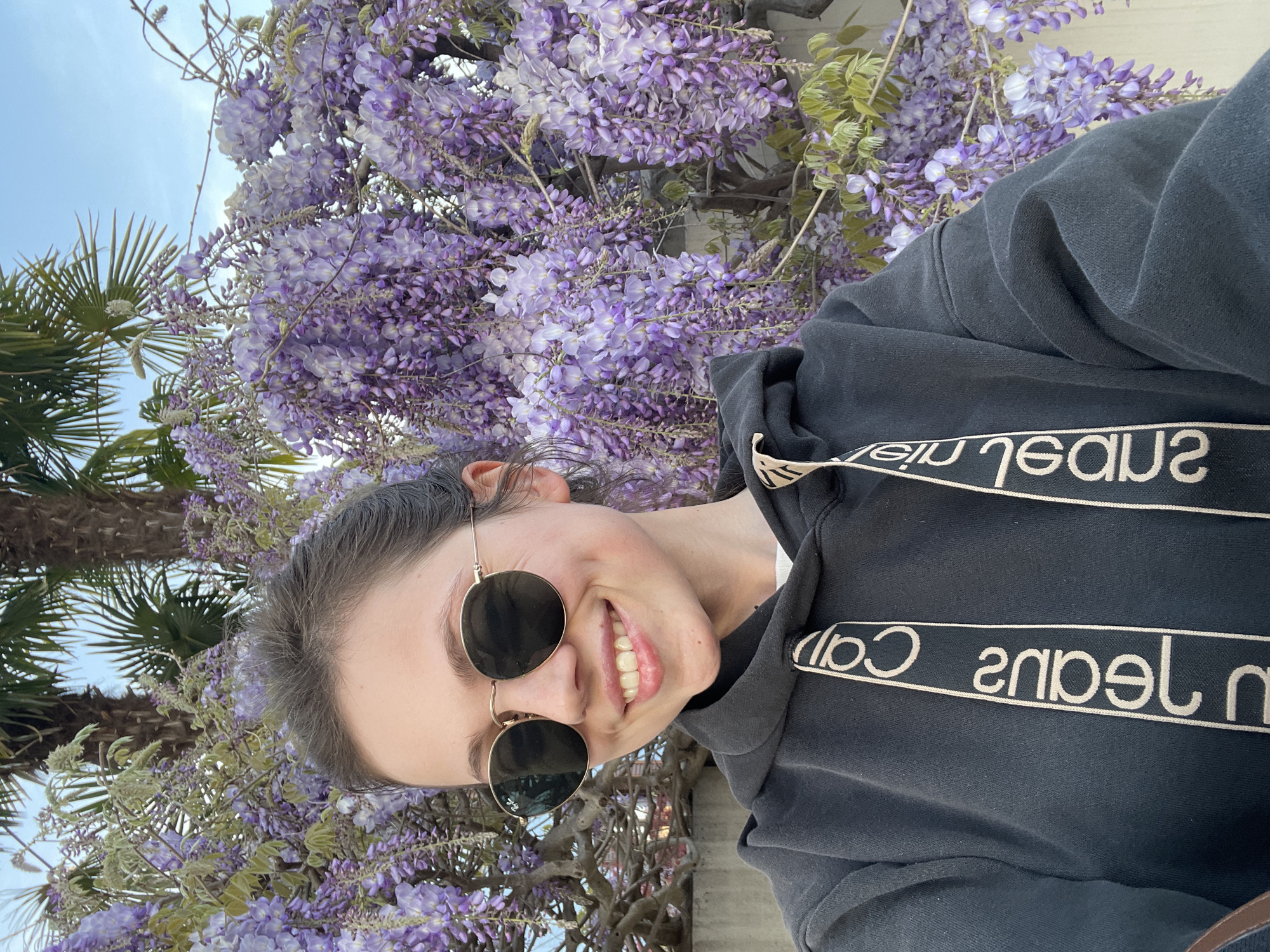Woman poses with spring wisteria blooms in northern Italy