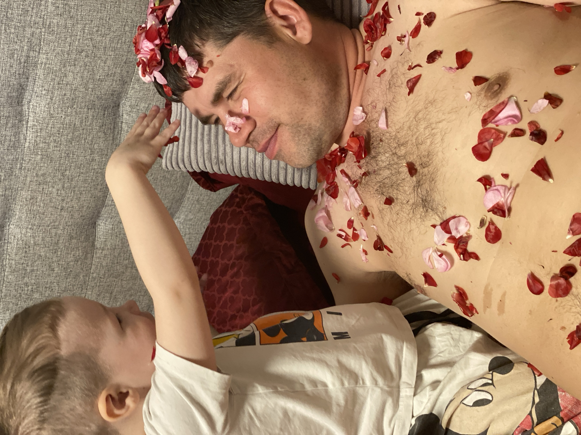 Child throws rose petals on resting man in Sochi home