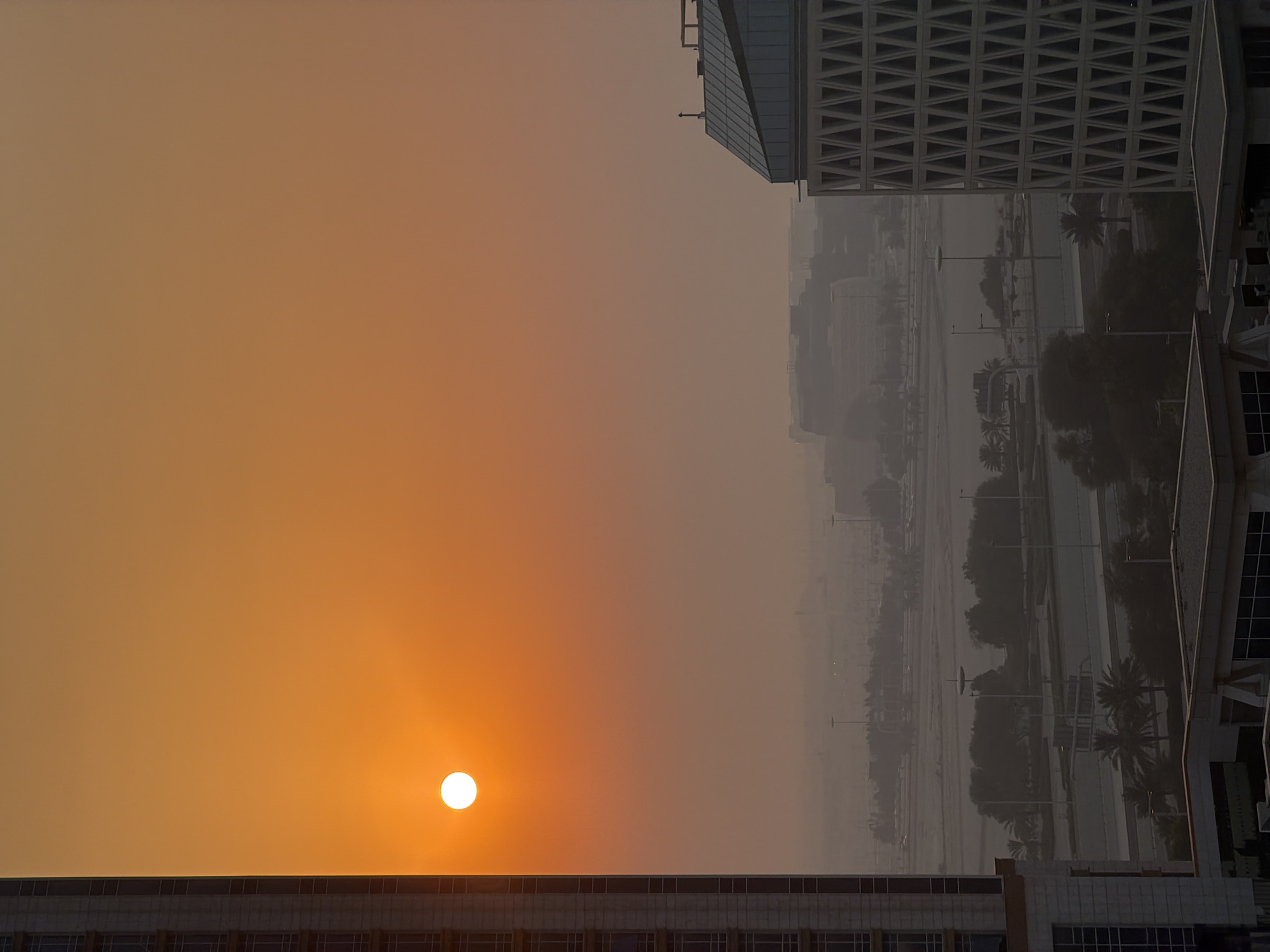 Lusail skyline glows under a hazy golden-hour sun