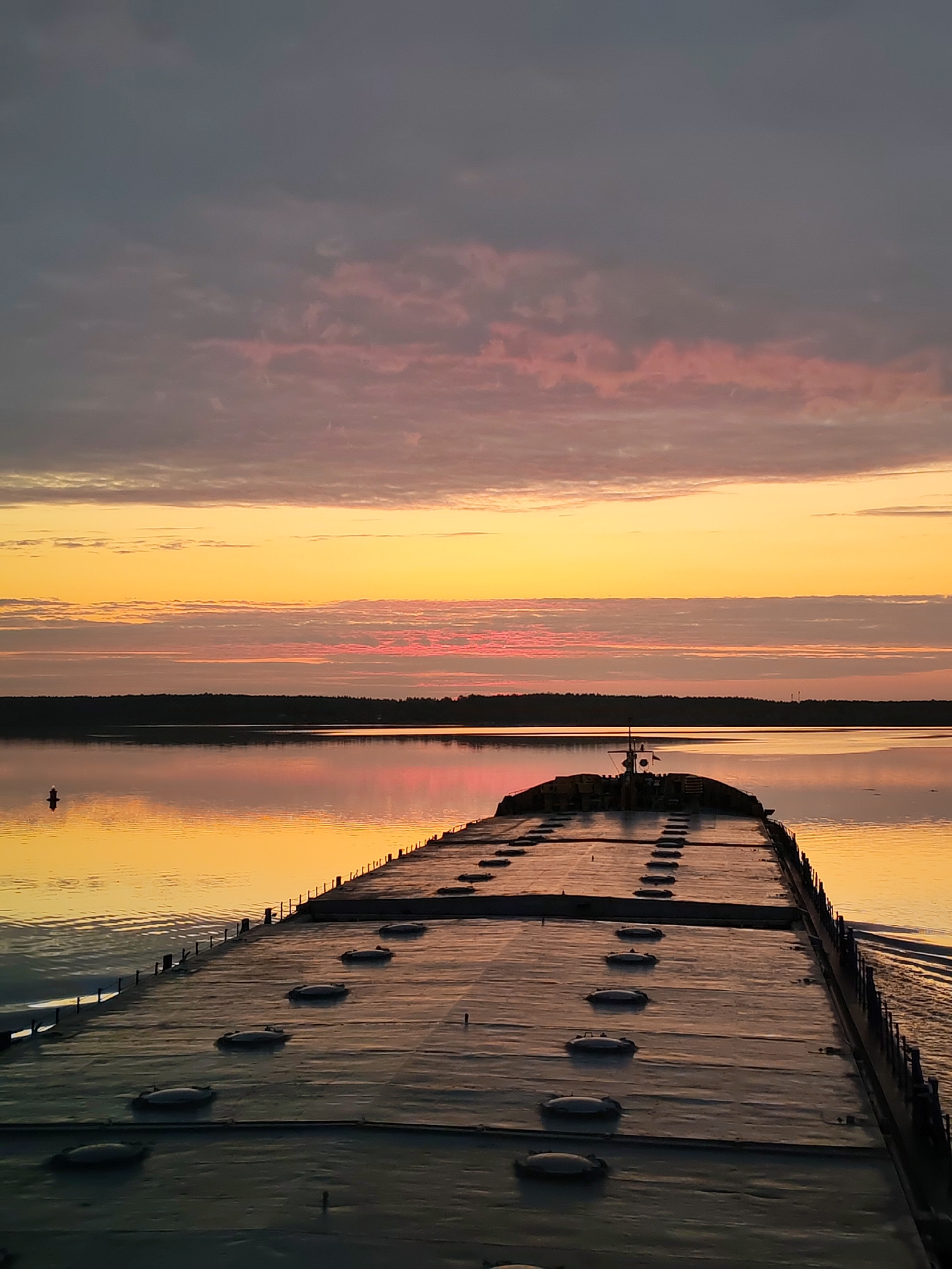 Cargo barge spotted on calm waters at sunset