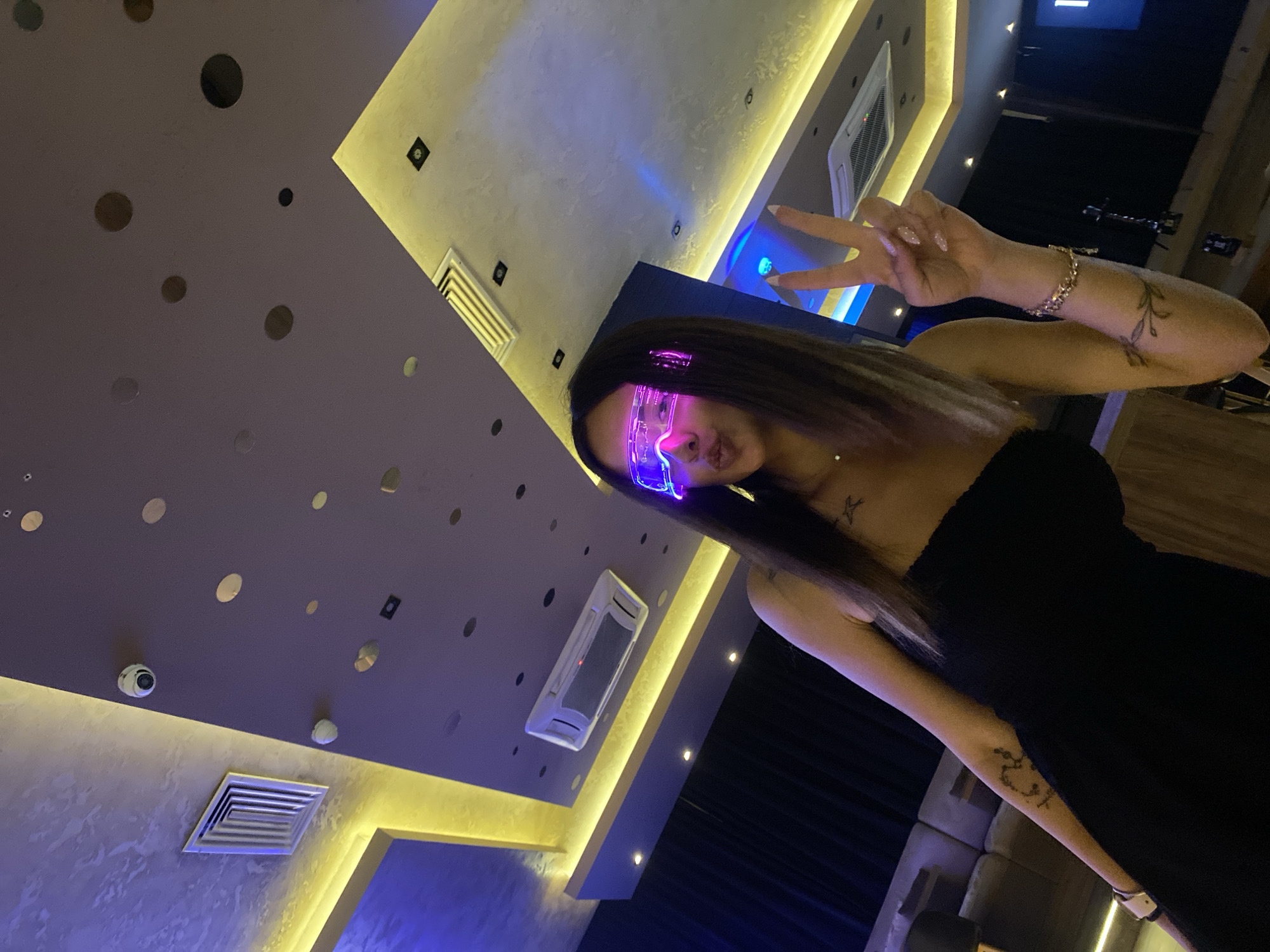 Woman in glowing glasses spotted in colorfully-lit Sofia room