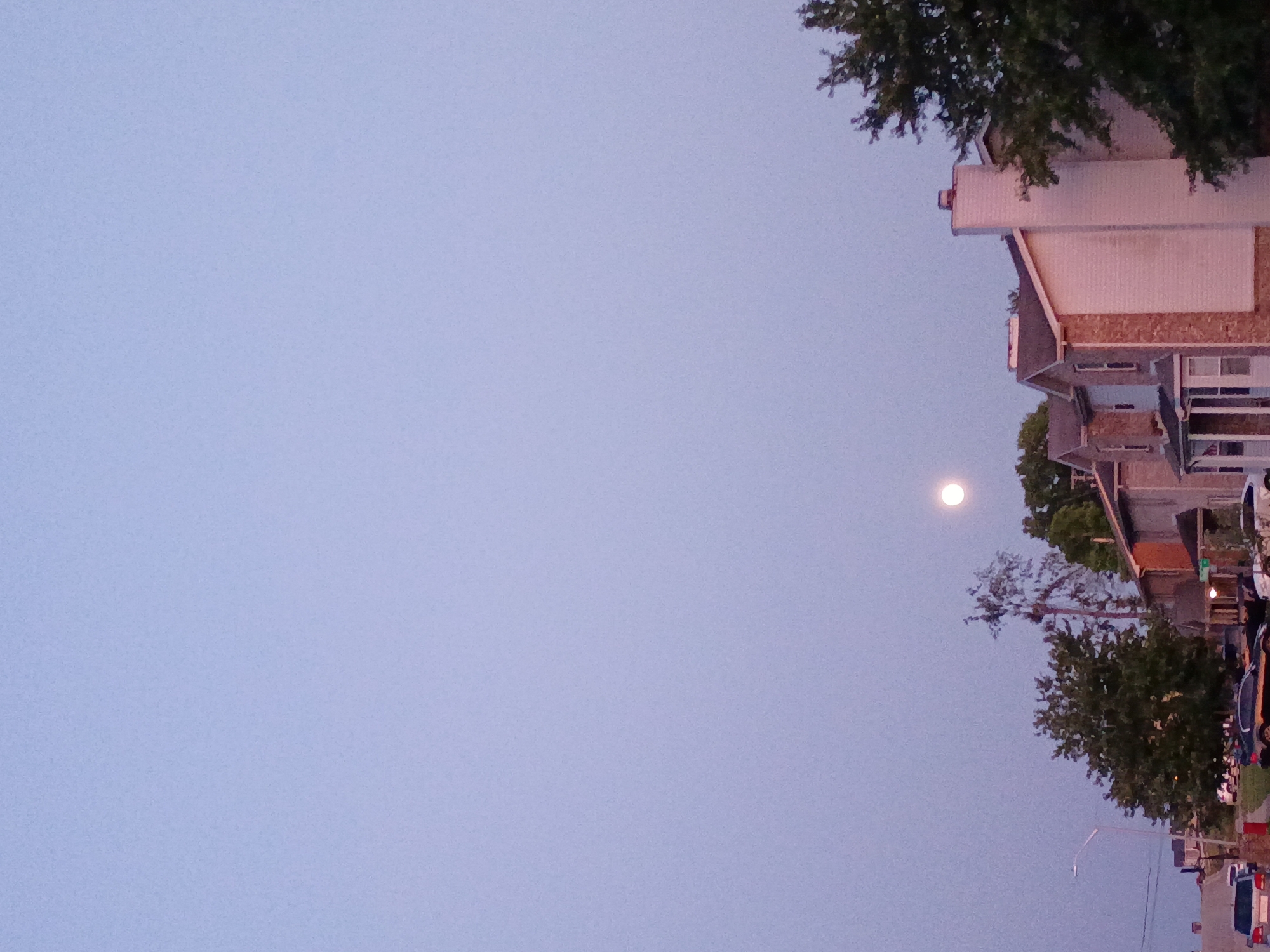 Full moon rises over quiet Nicholasville streets at dusk