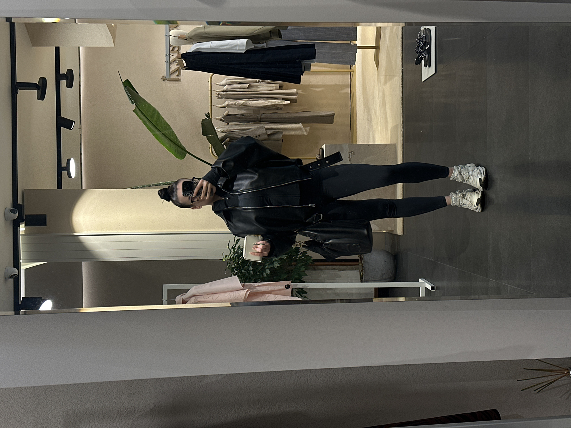 Woman takes mirror selfie in Sofia clothing store